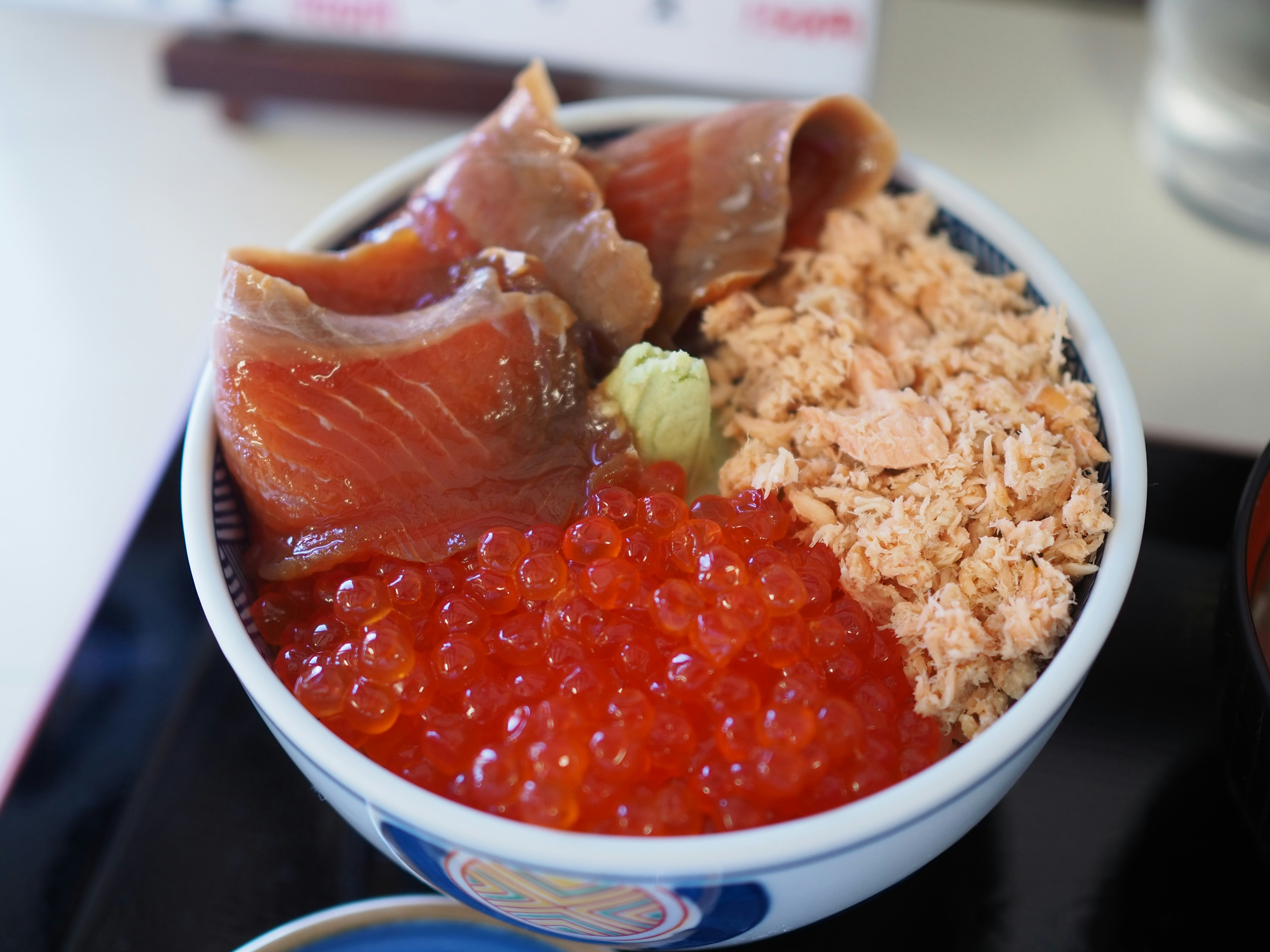 Ciotola di sashimi di salmone e uova di salmone con wasabi