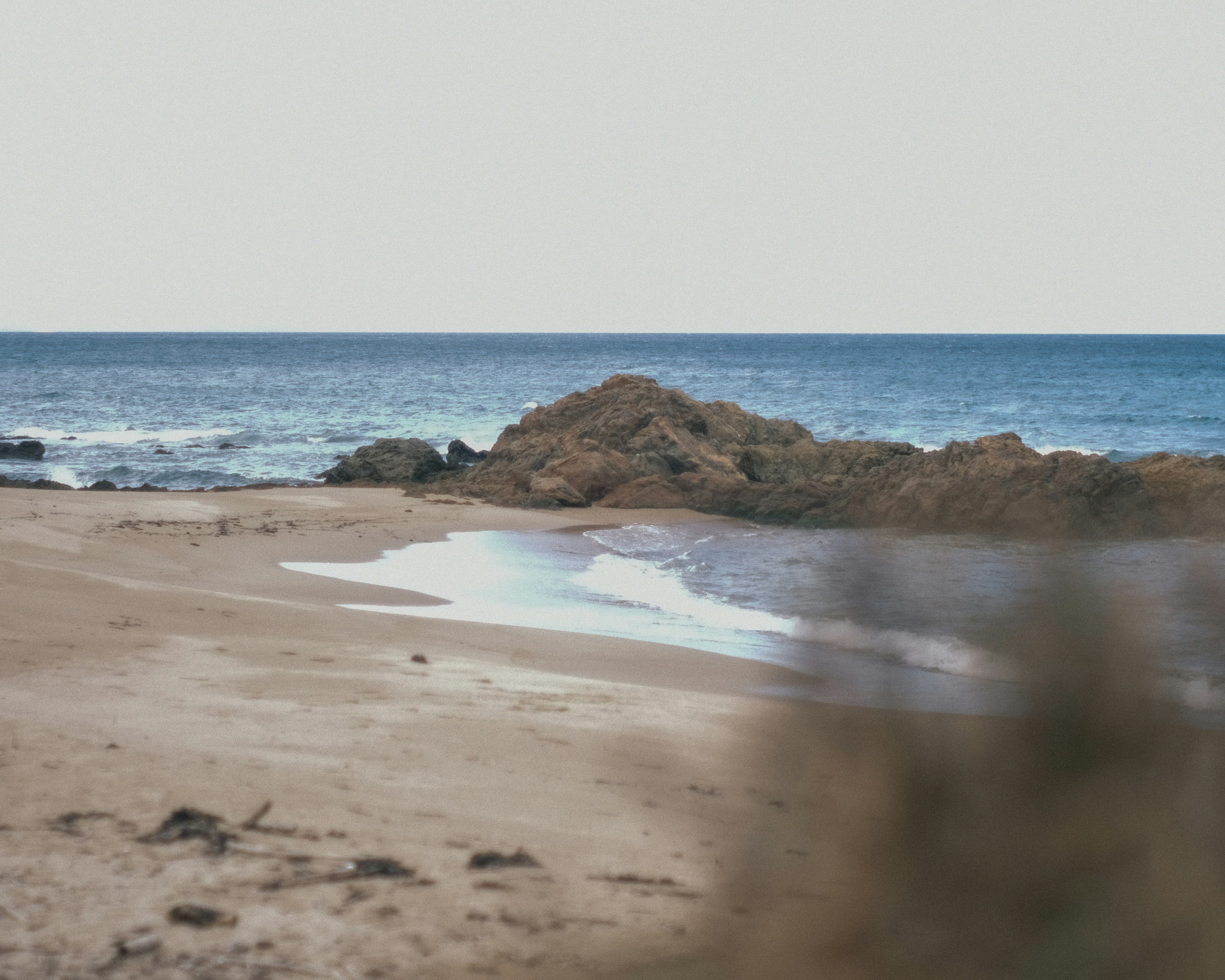 Vista panoramica di una spiaggia sabbiosa con rocce e oceano