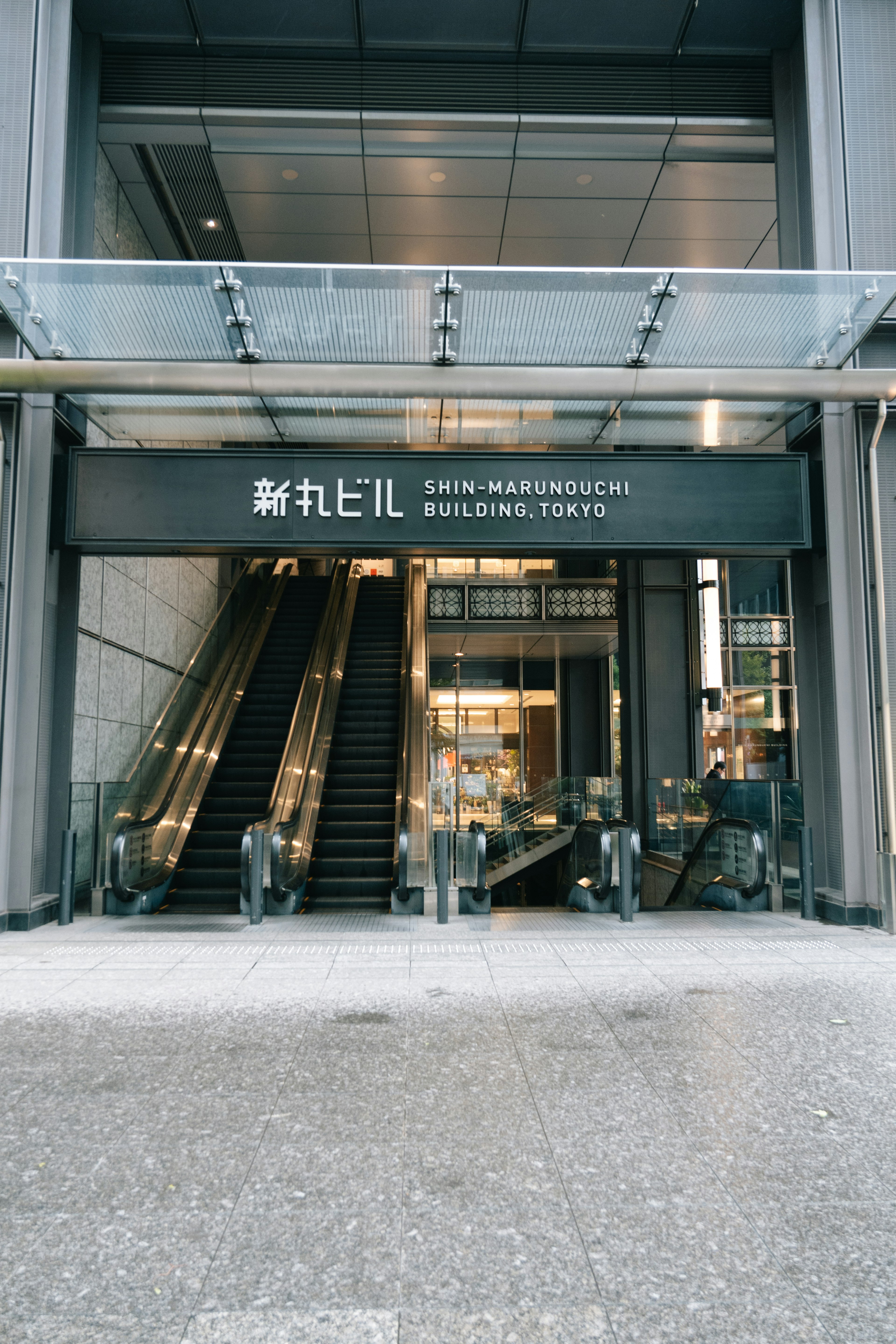 Entrada a la estación de Shinjuku con escaleras mecánicas y arquitectura moderna