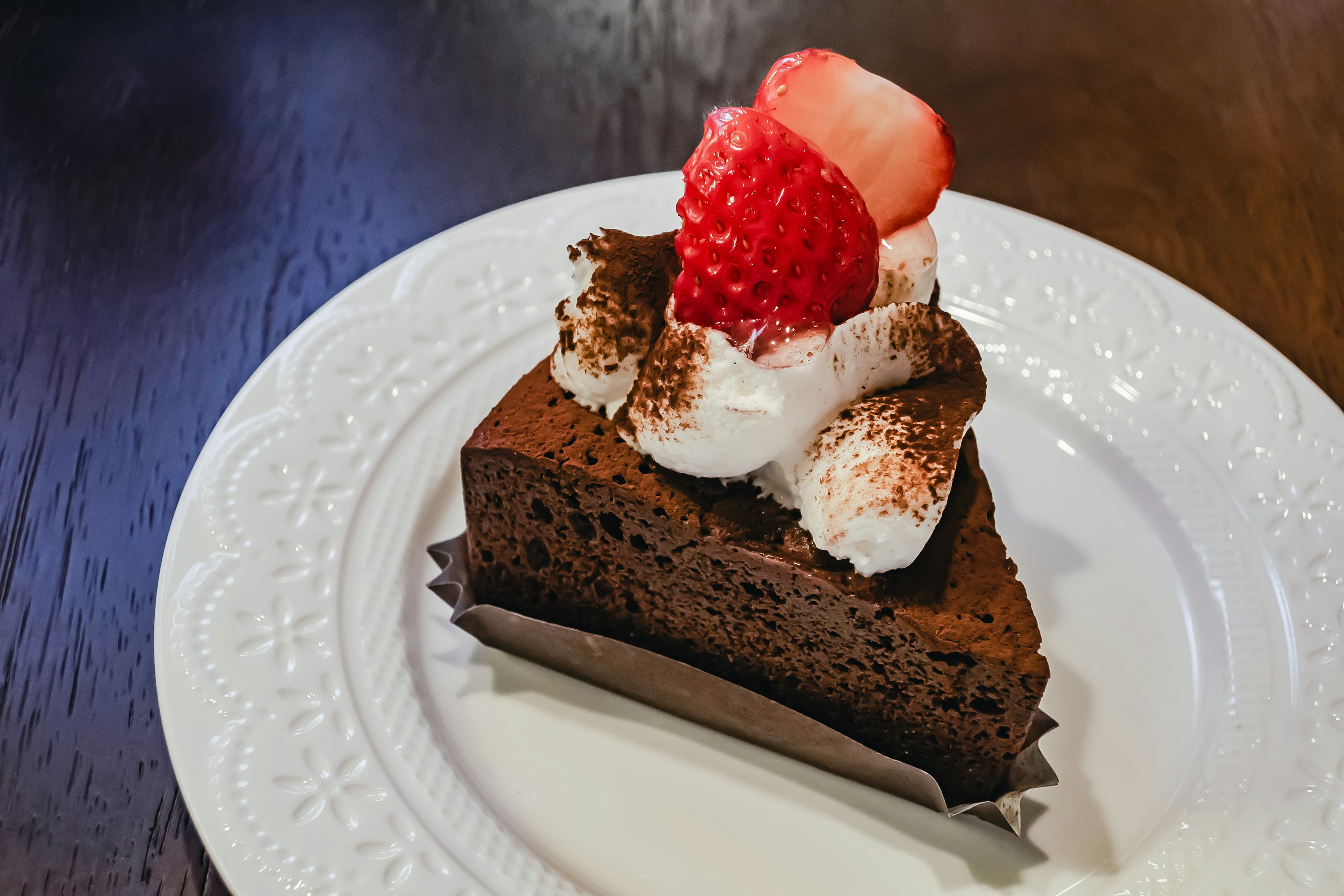 Stück Schokoladenkuchen mit Schlagsahne und Erdbeeren