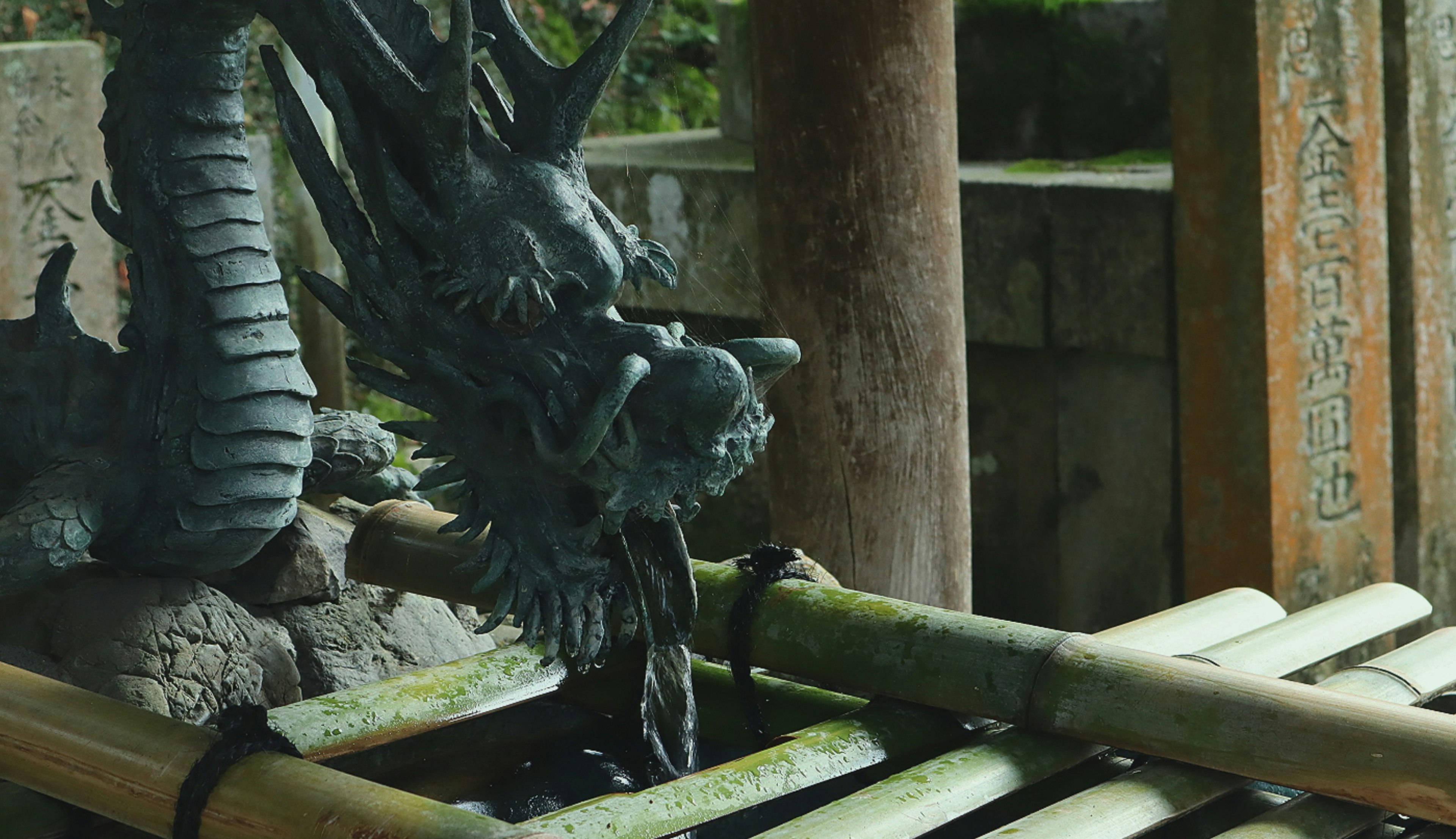 Sculpture de dragon buvant dans un bassin en bambou