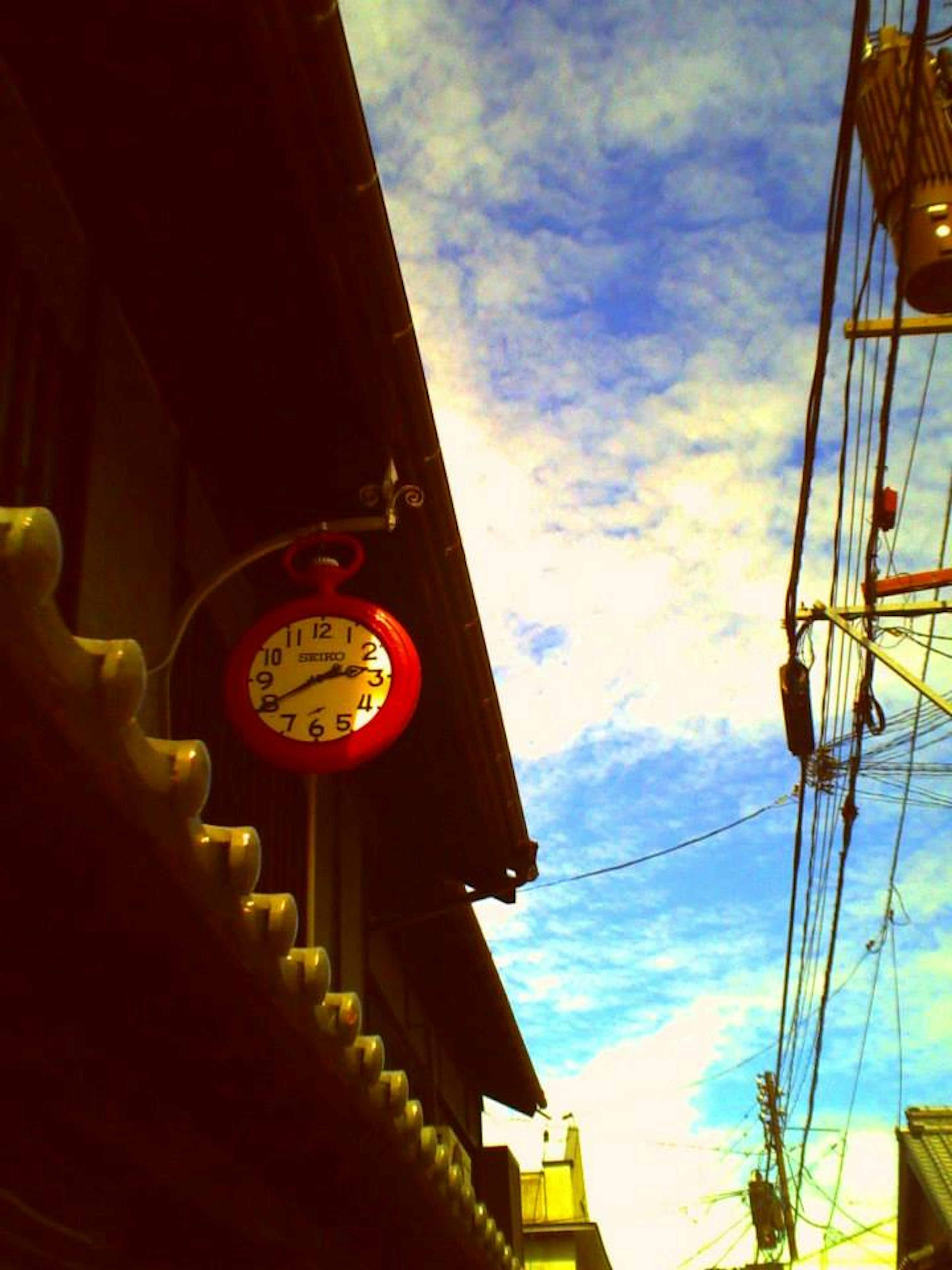 Red clock on an old building with a blue sky