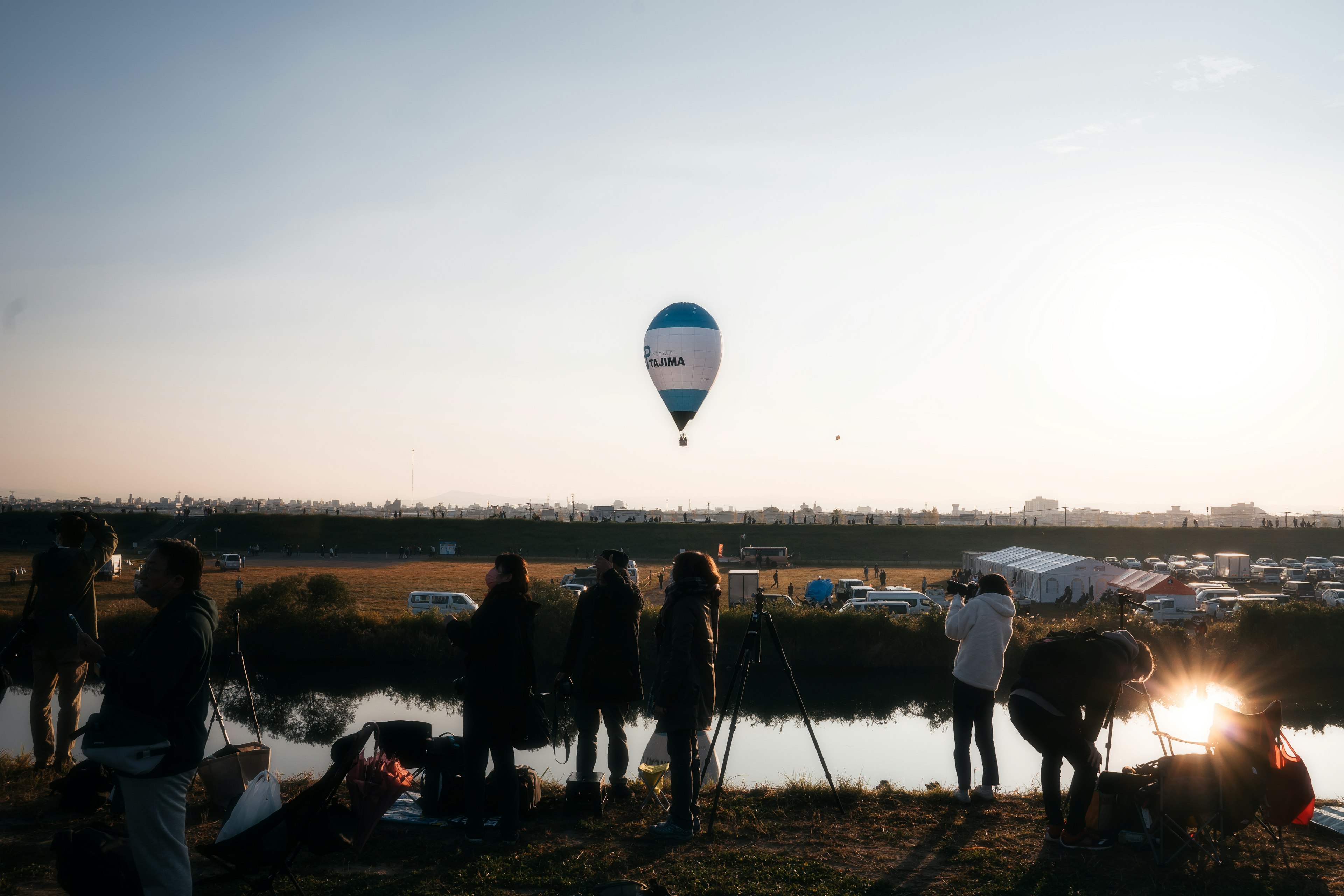 Una mongolfiera che fluttua nel cielo con un gruppo di persone che guardano