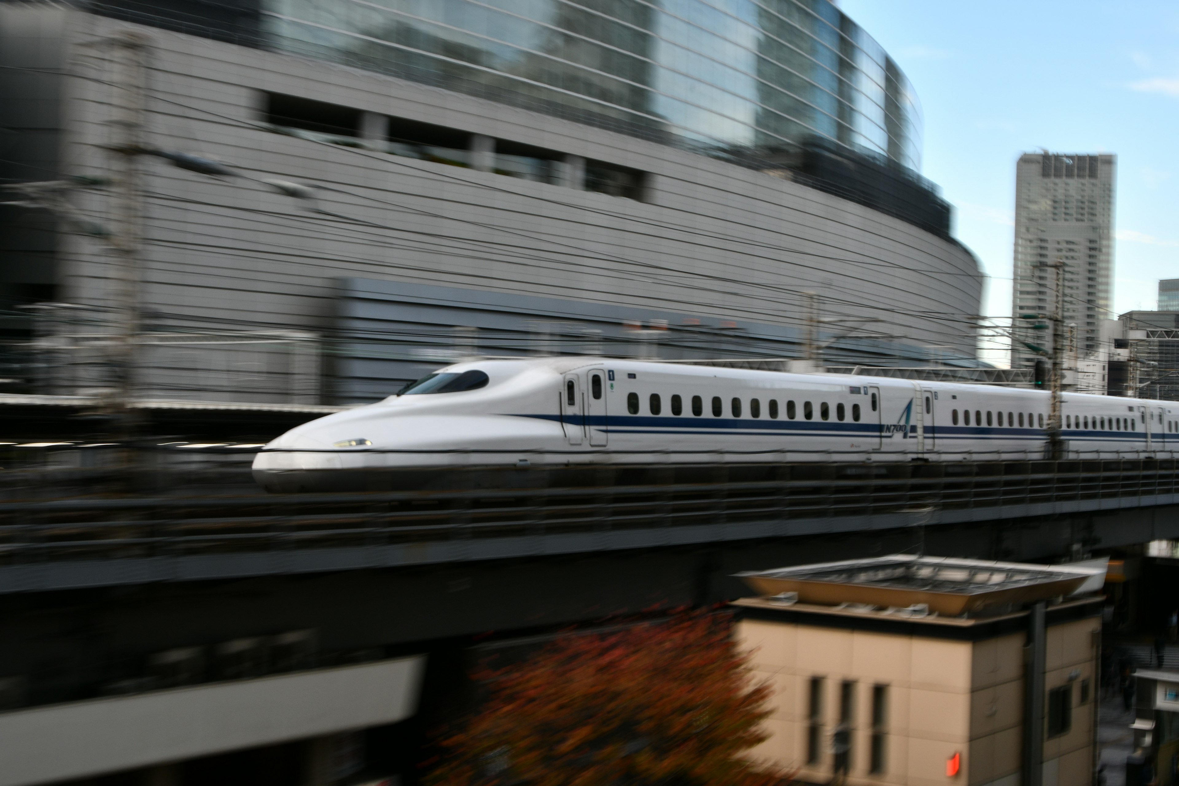 Shinkansen speeding past urban skyscrapers