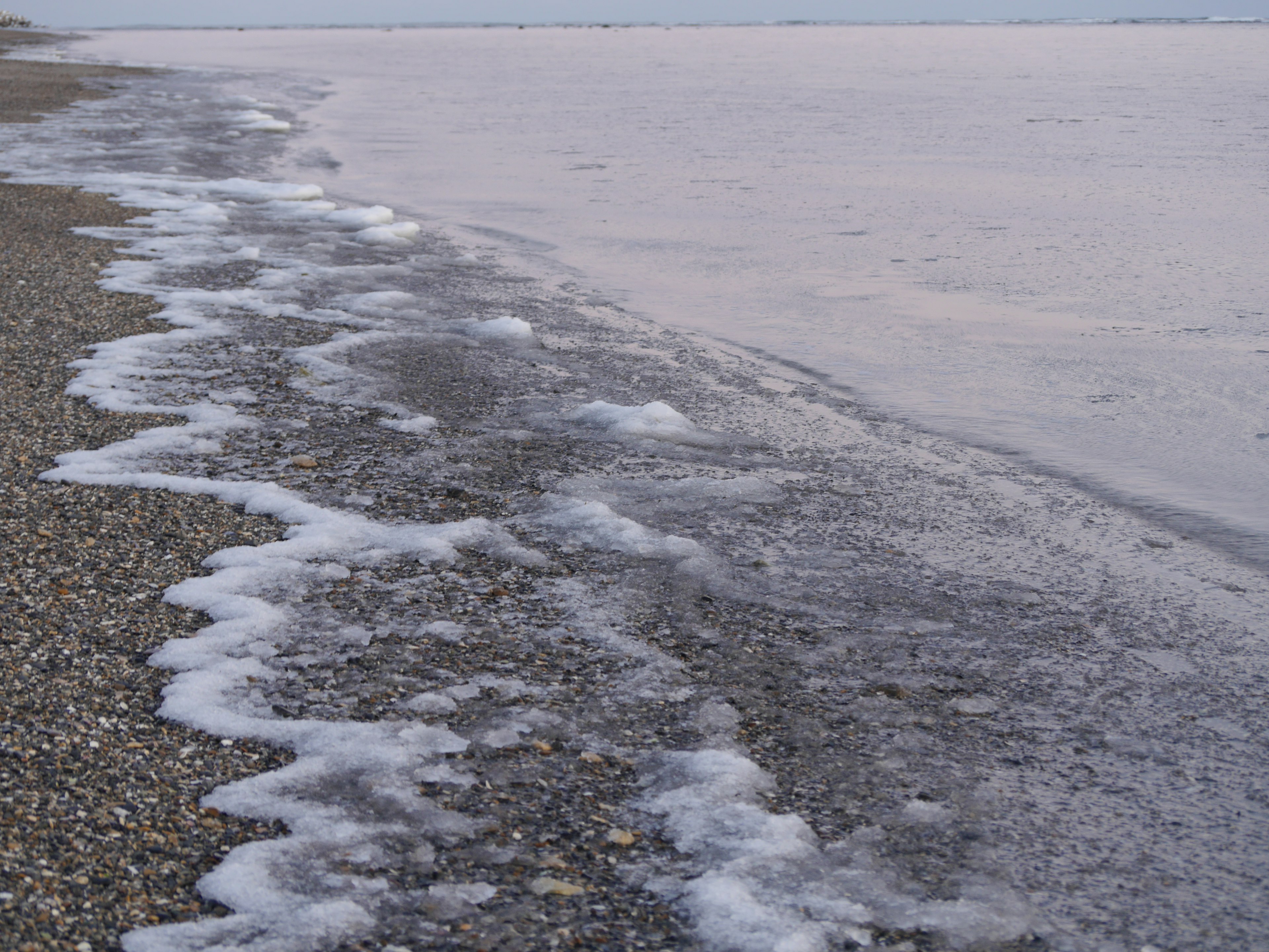 Küstenansicht mit Wellen und Kiesstrand