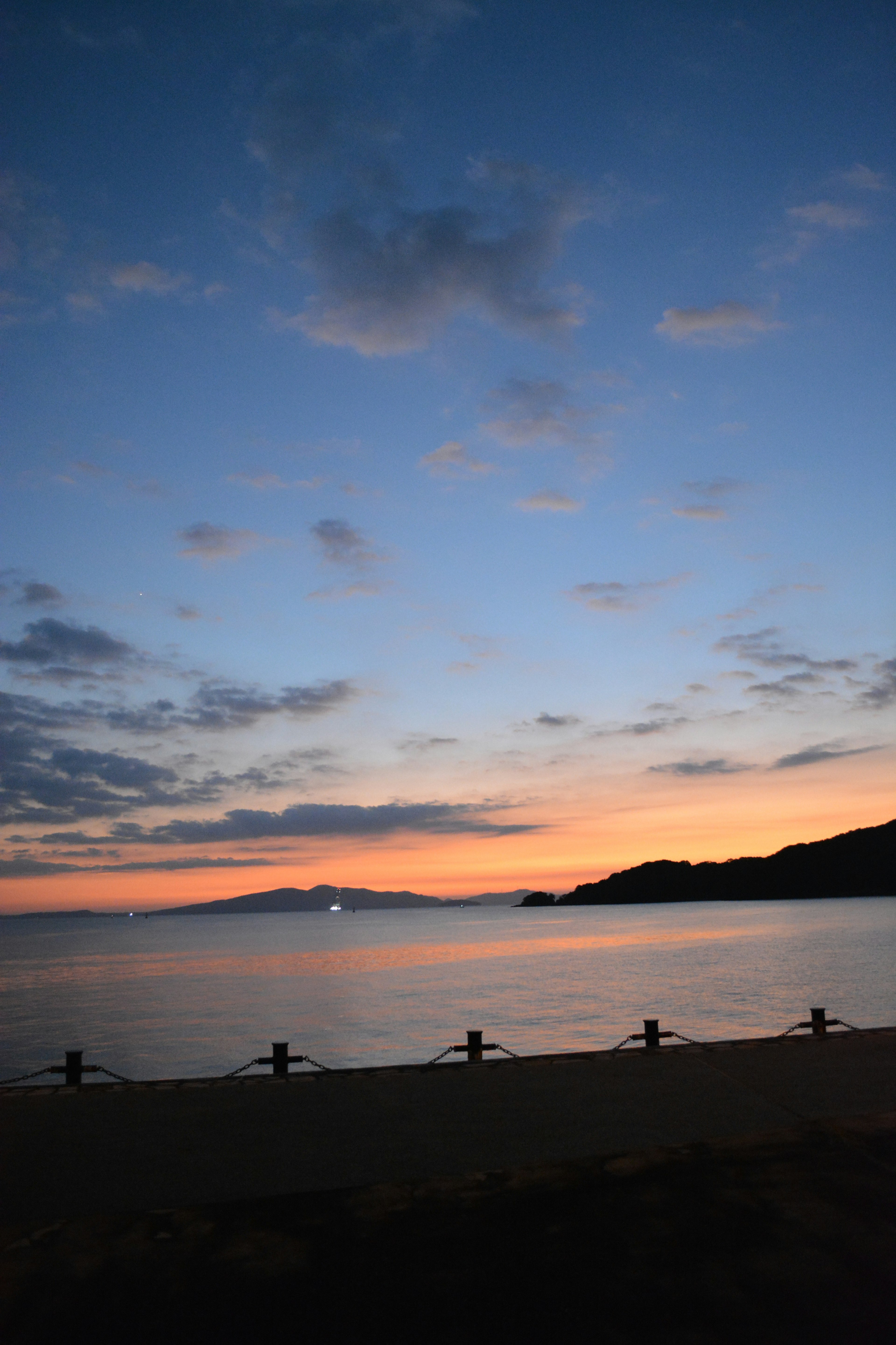 夕焼けの海岸と山のシルエットが映える美しい風景