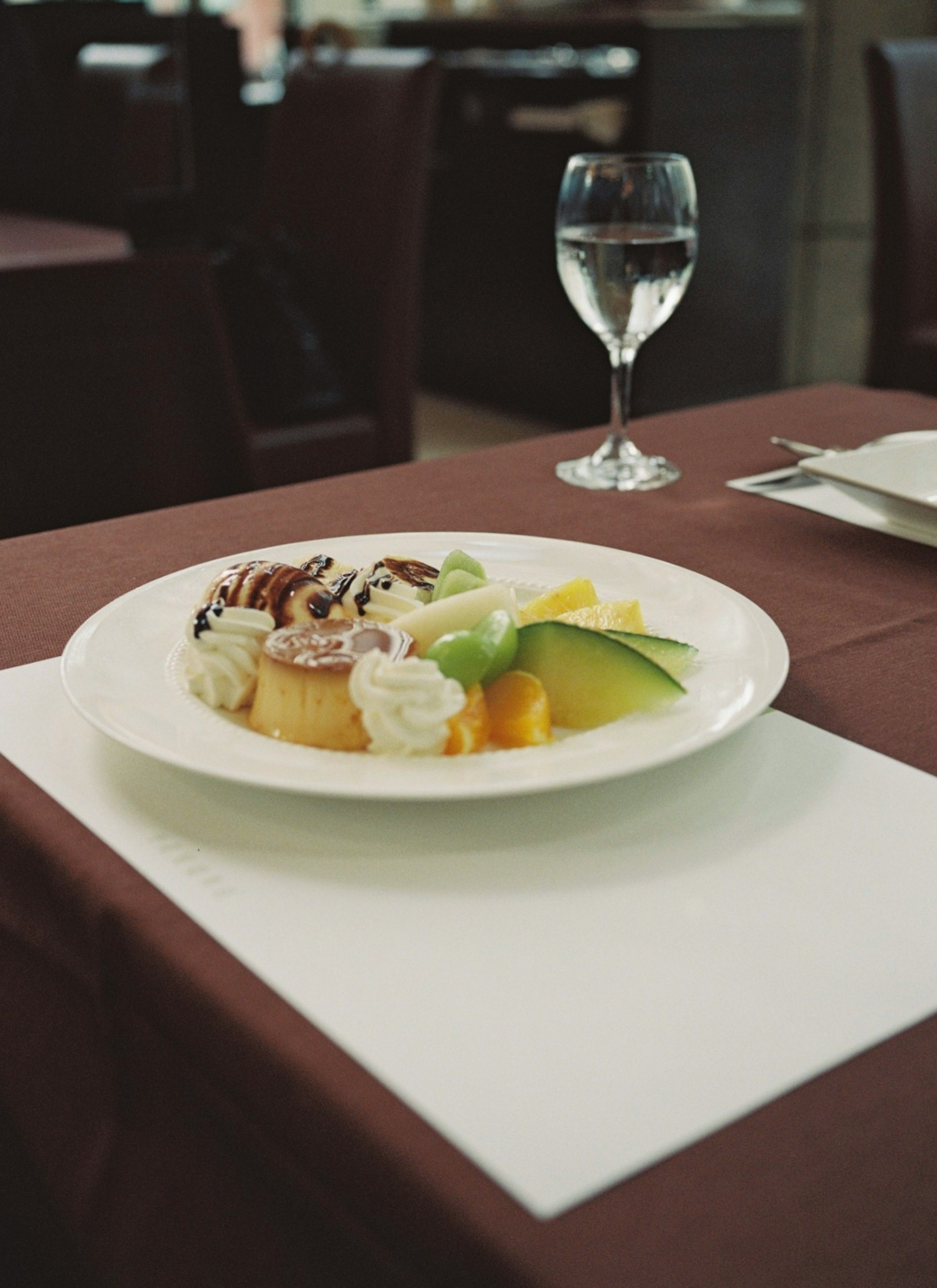 A beautifully arranged dessert plate on a table with a glass of water