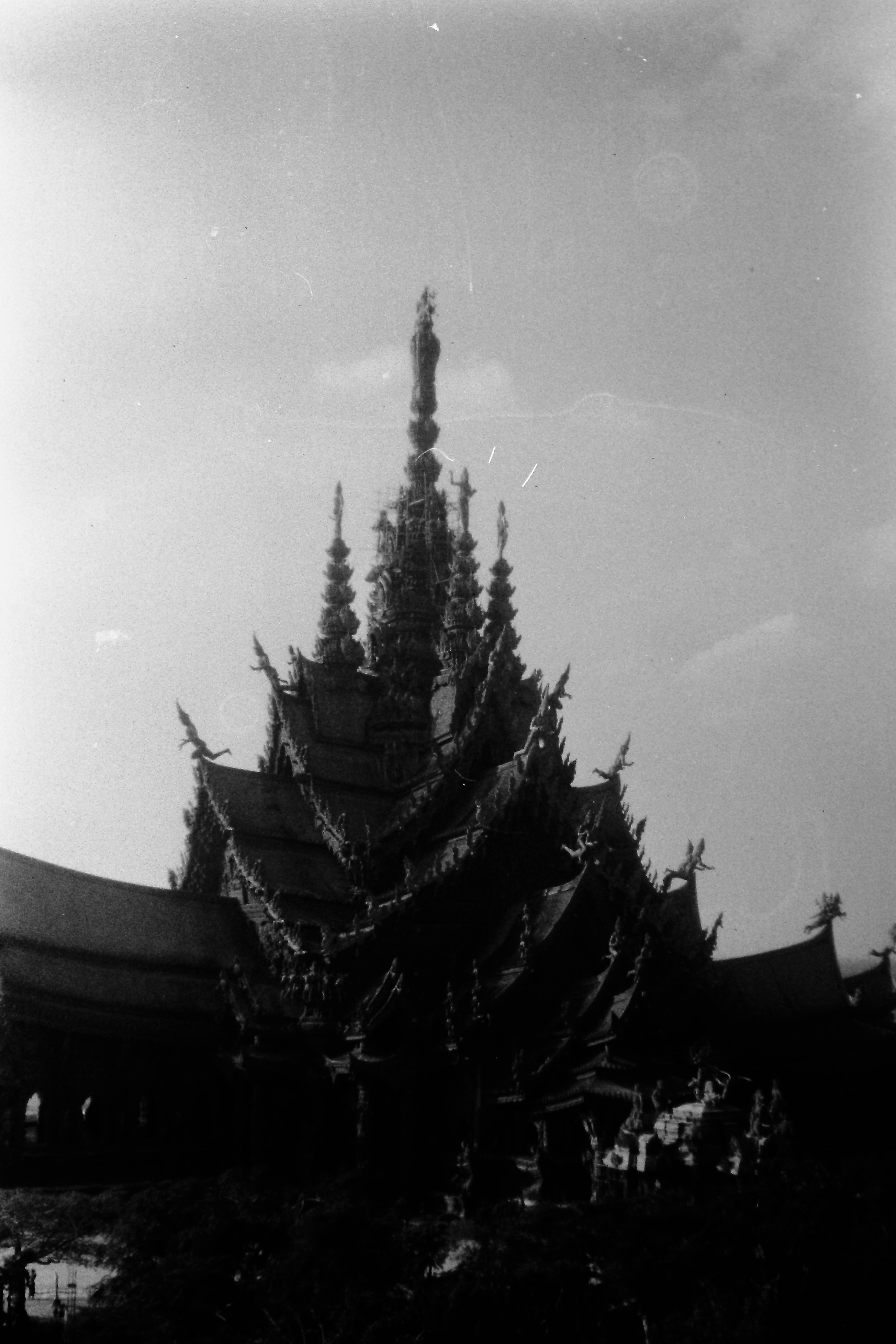 Silhouette of a temple spire against a cloudy sky