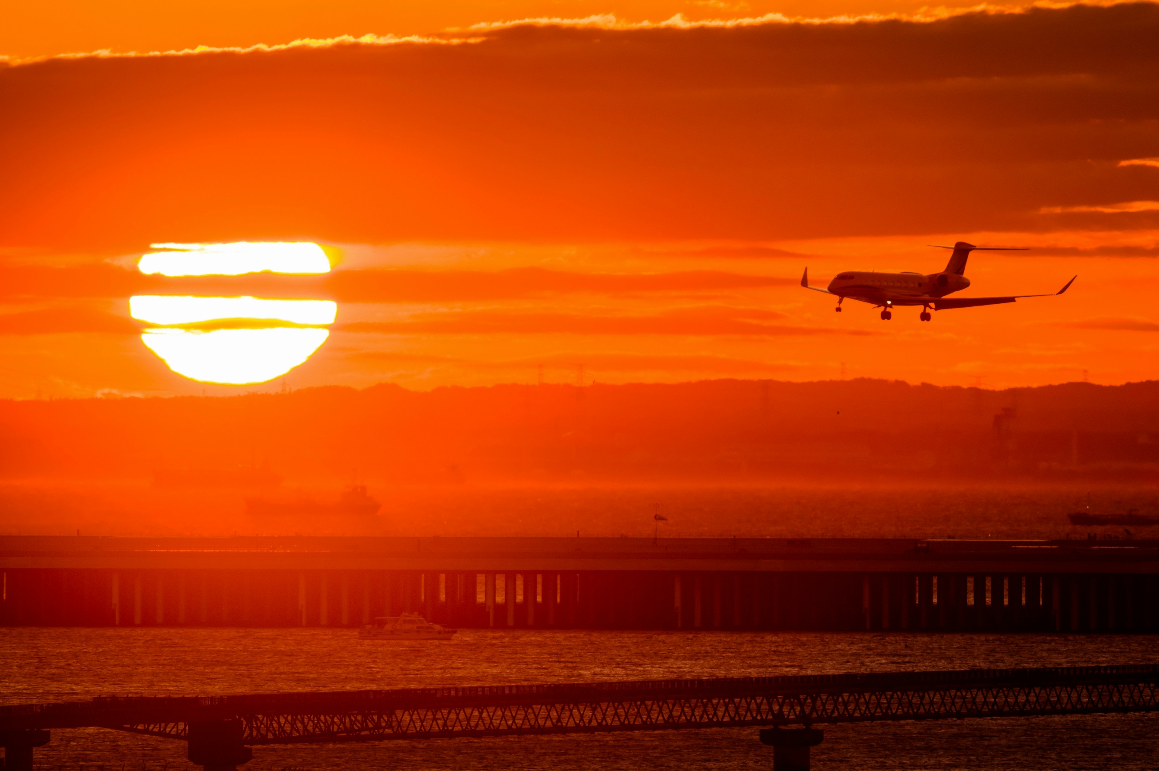 Silhouette di un aereo in atterraggio contro un tramonto