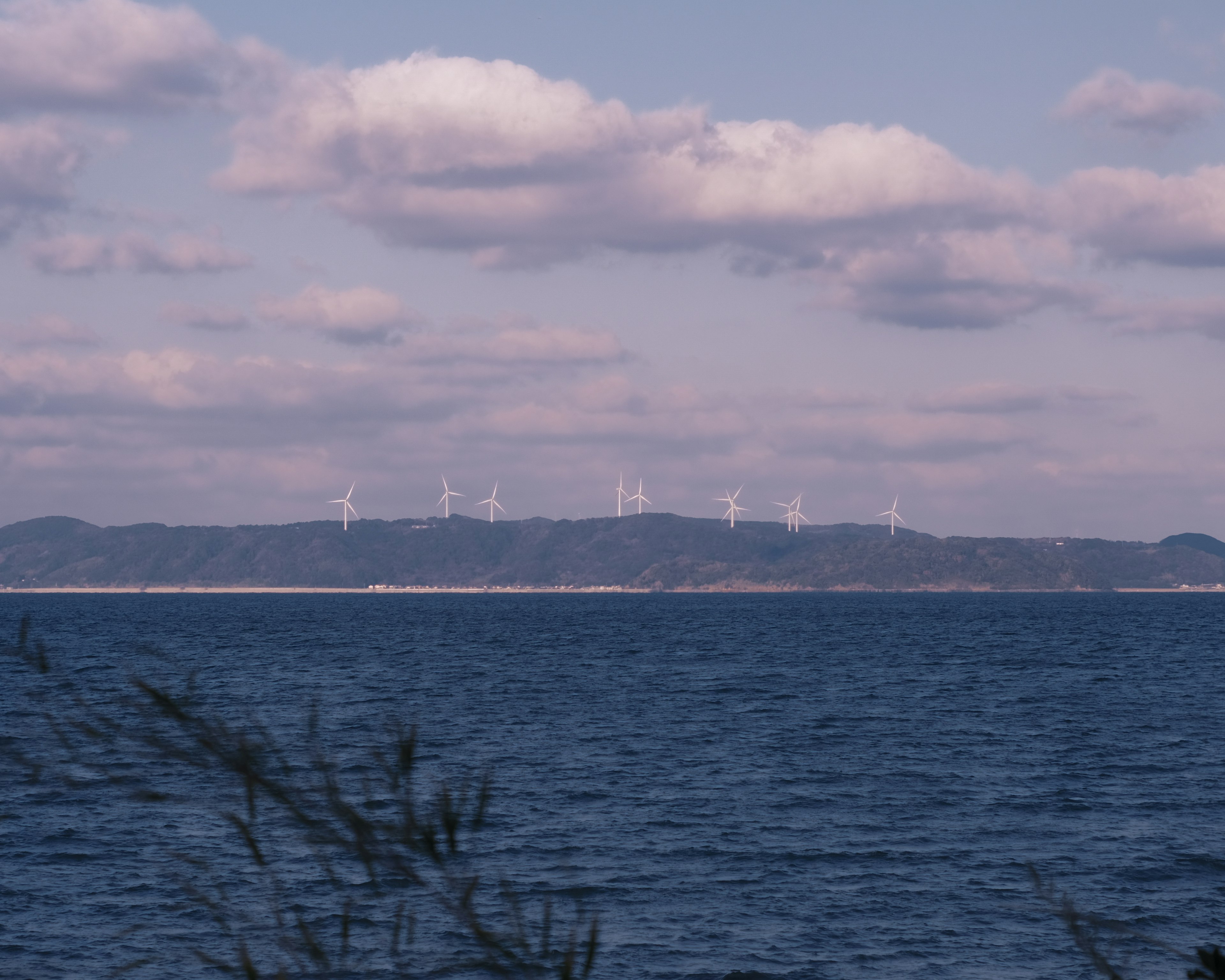 Vista panoramica del mare con turbine eoliche sullo sfondo