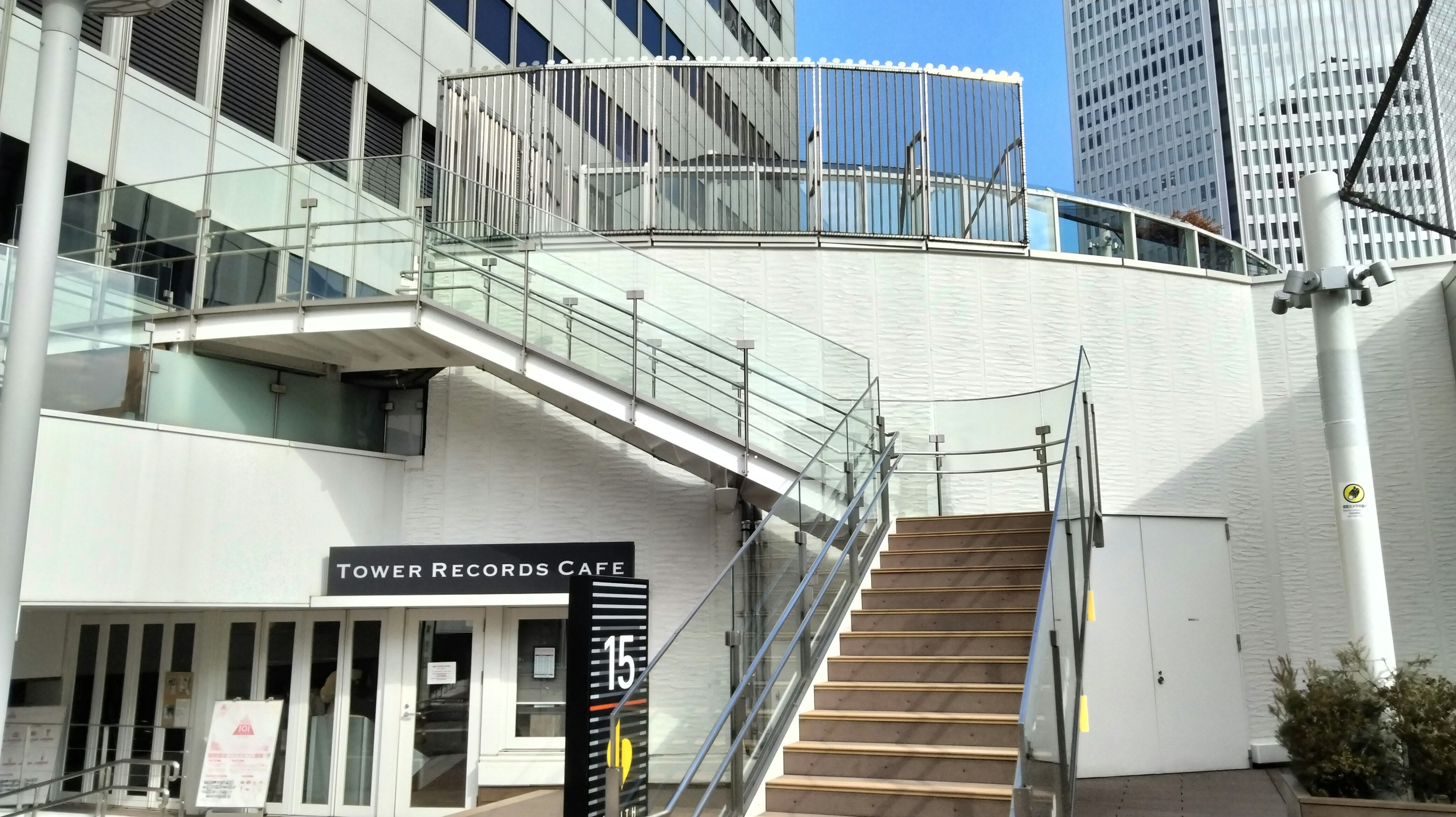 Staircase with glass railing and white exterior wall