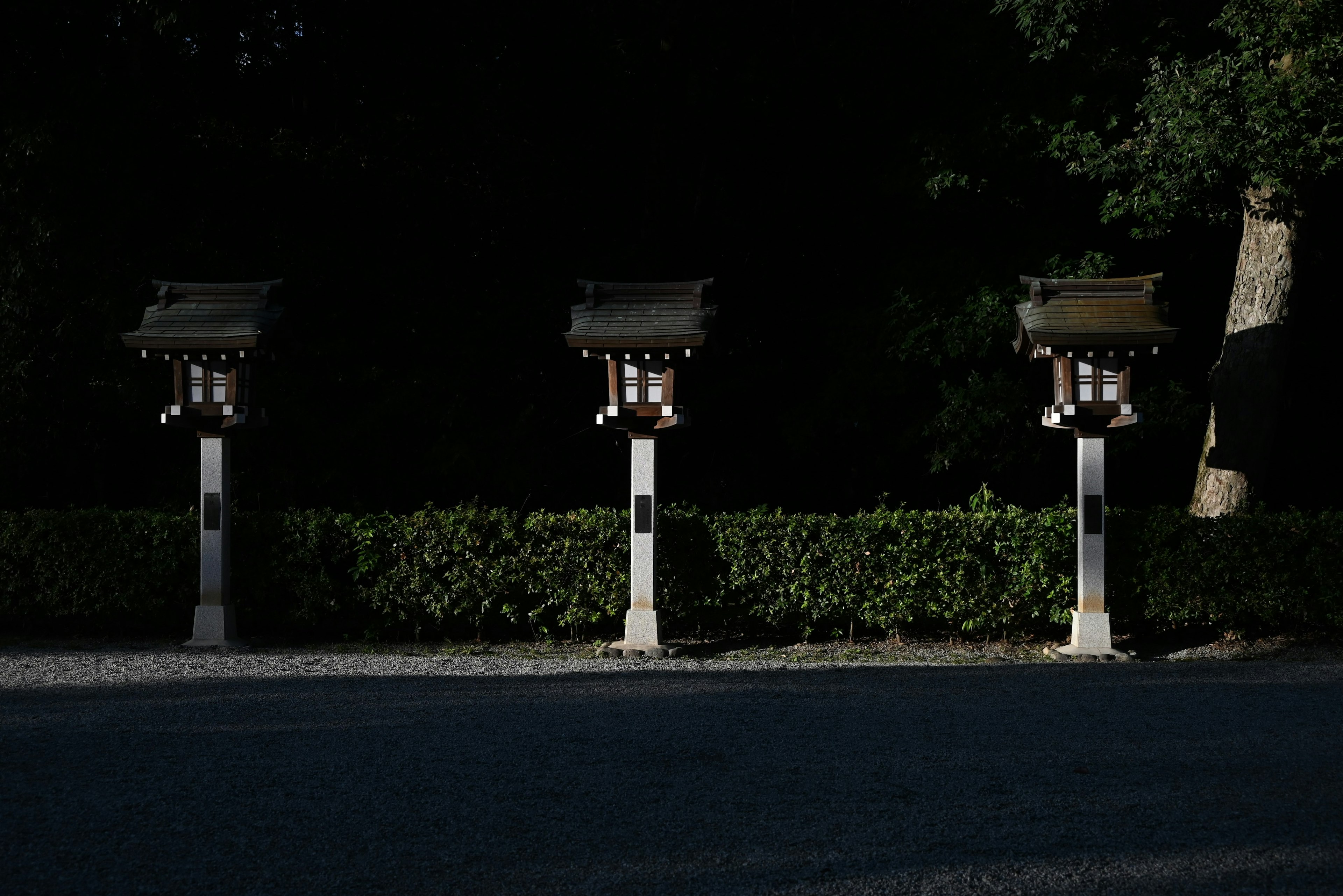 Three lanterns standing against a dark background