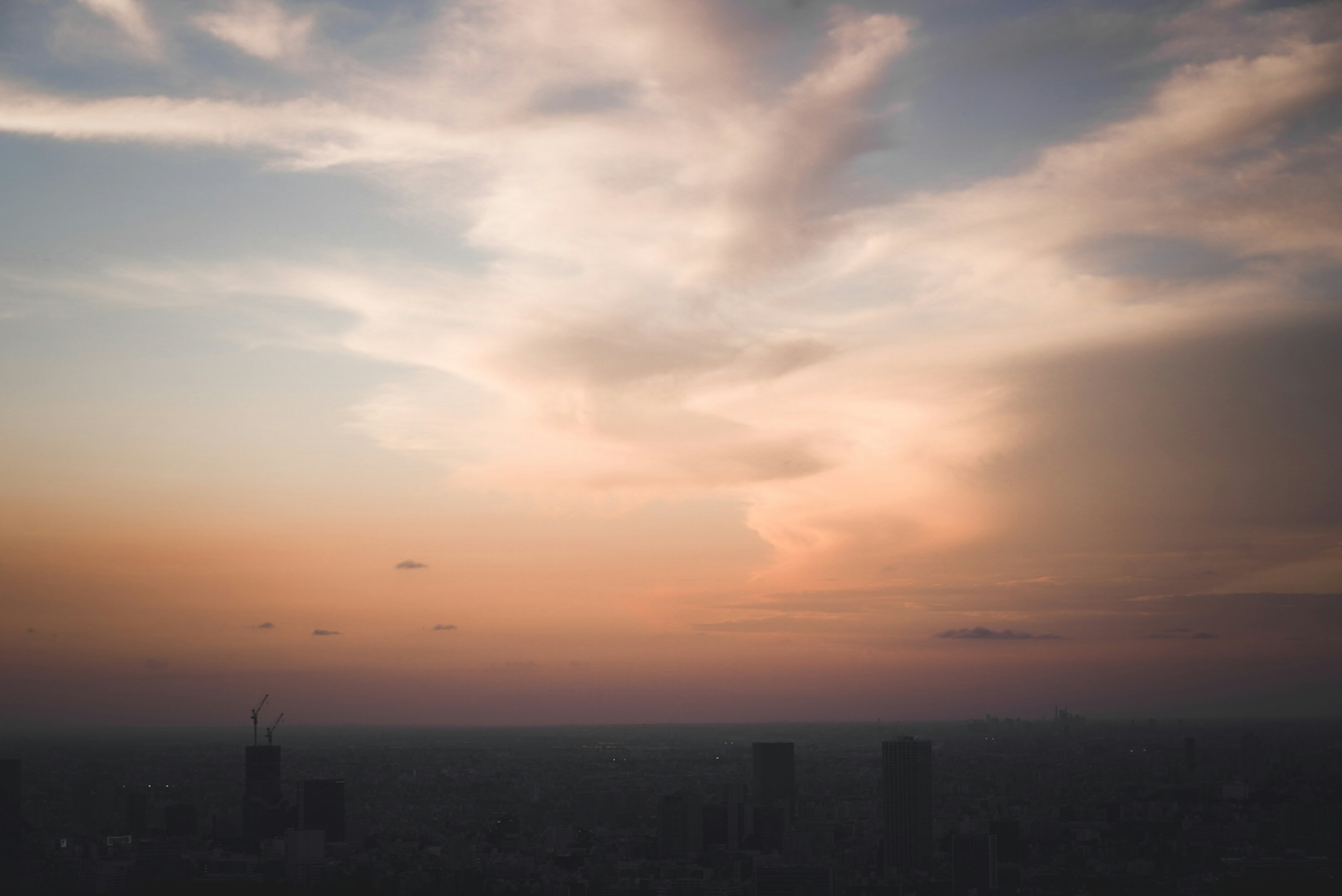 Cielo de atardecer con silueta de la ciudad al fondo