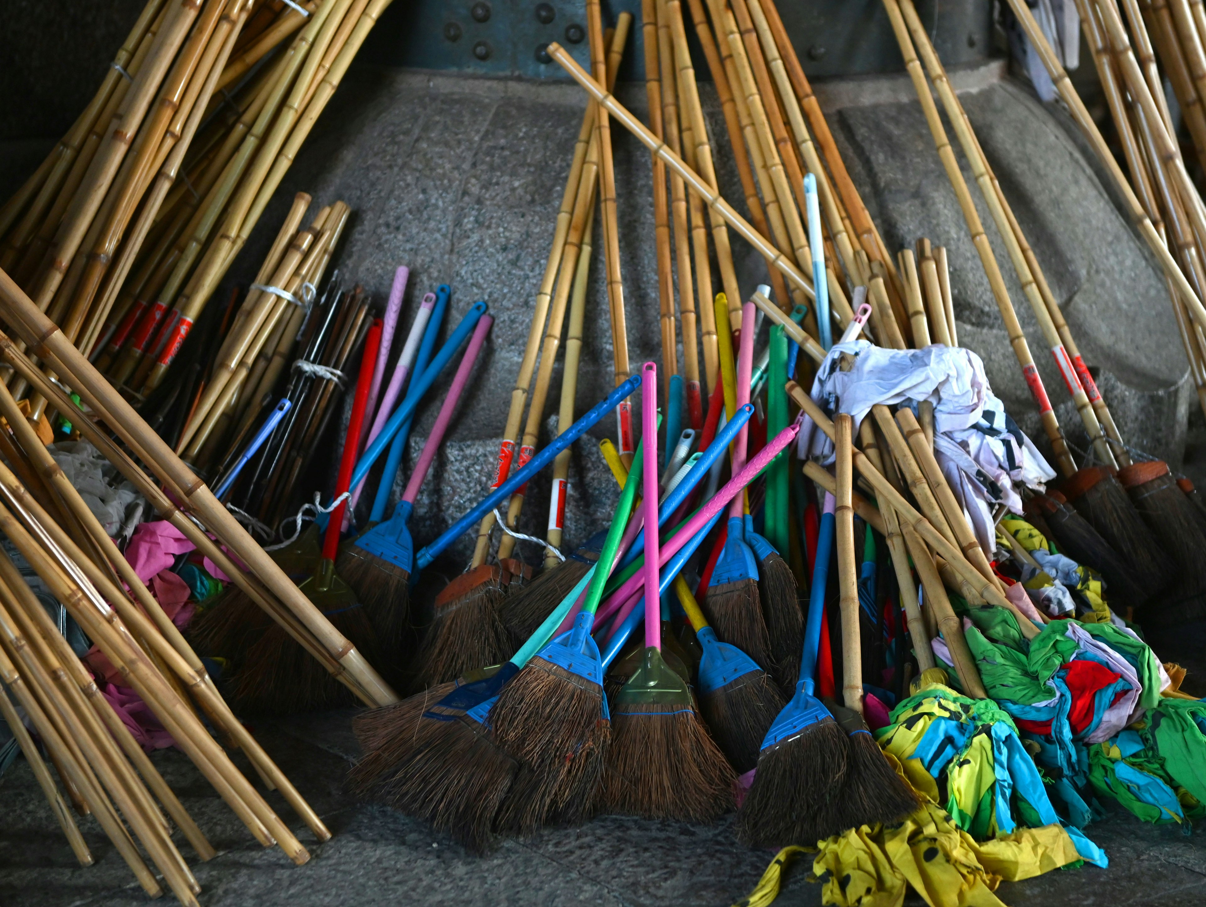 Colorful brooms and bamboo sticks arranged on the ground