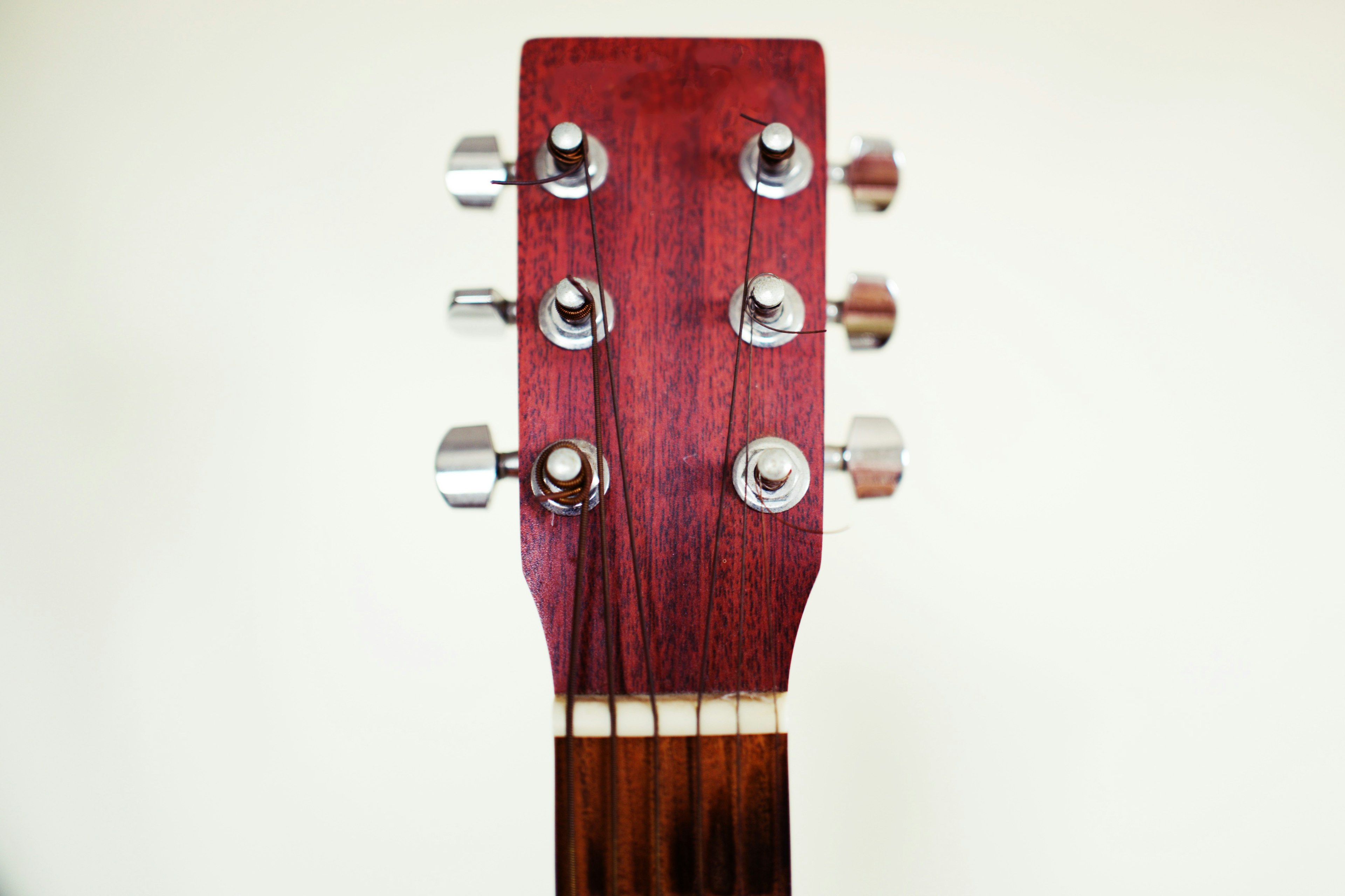 Close-up of guitar headstock featuring silver tuning pegs and beautiful wood grain