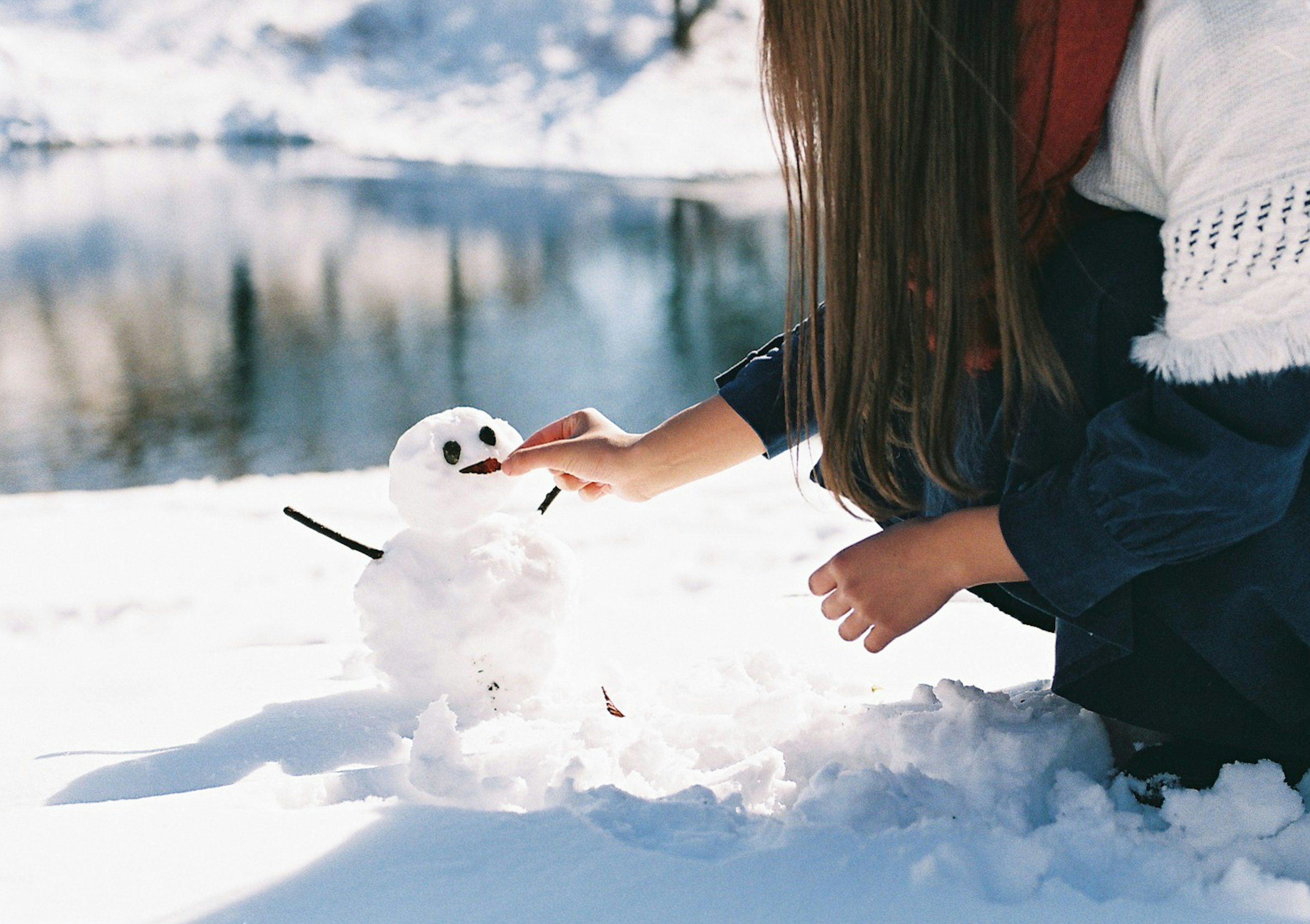 雪の中で雪だるまを作る女の子の姿