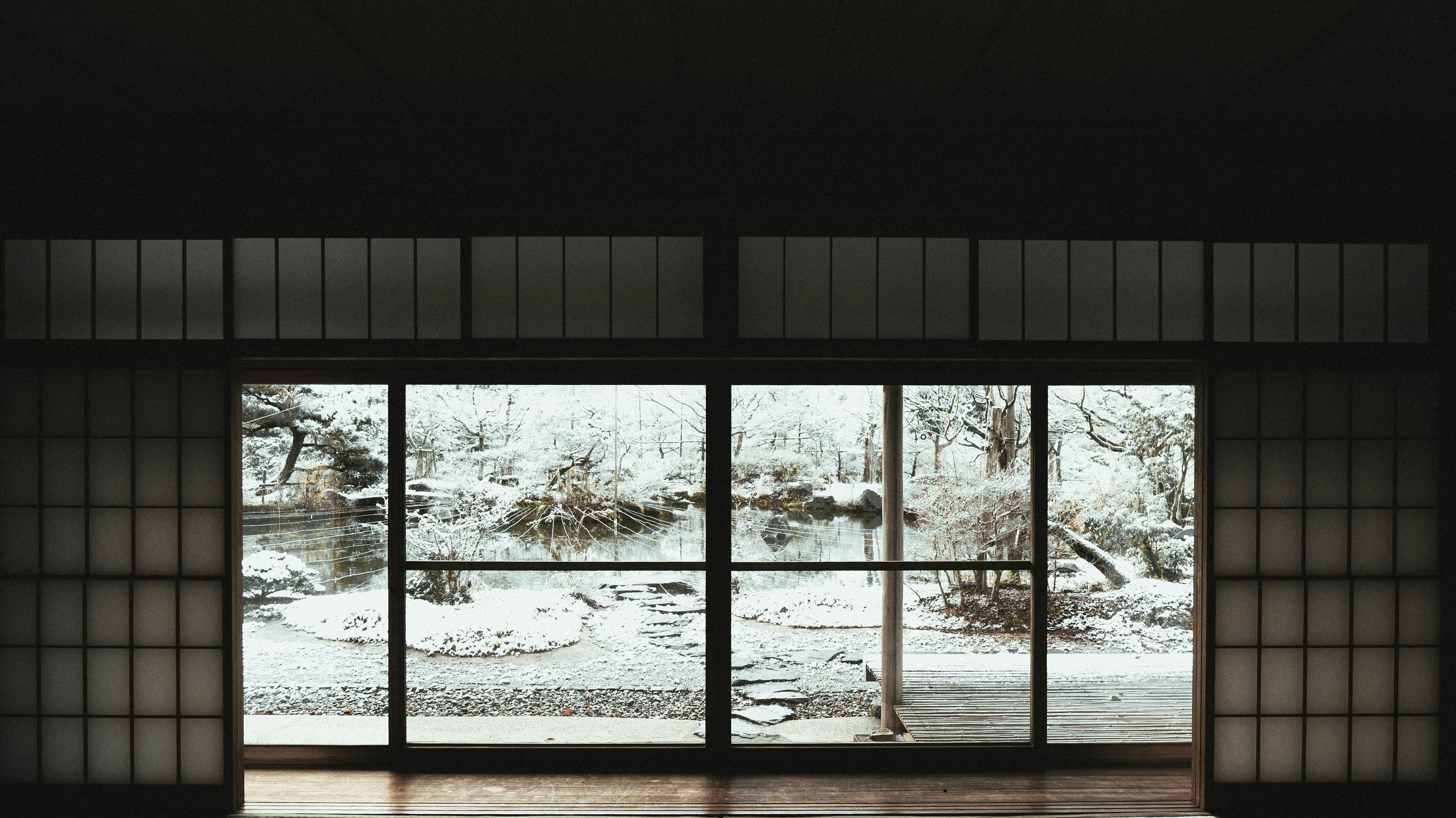 Großes Fenster eines traditionellen japanischen Raumes mit Blick auf eine verschneite Landschaft