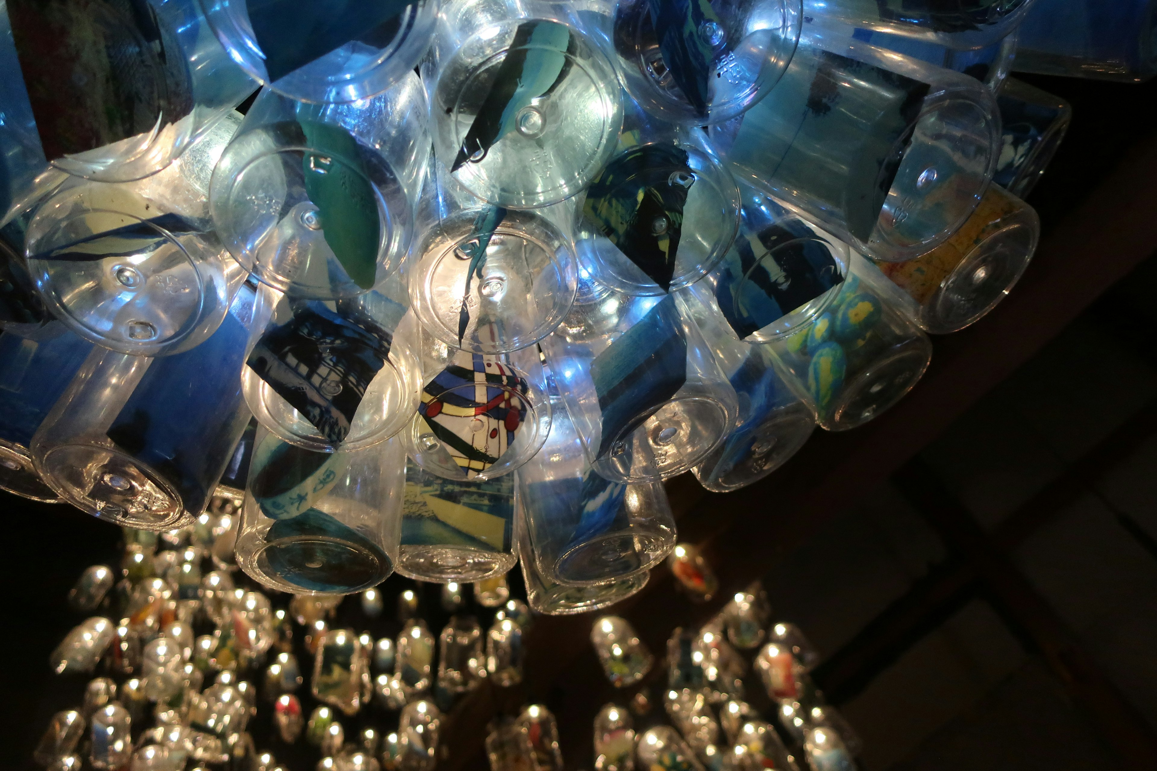 Unique chandelier made from transparent plastic bottles reflecting light while suspended