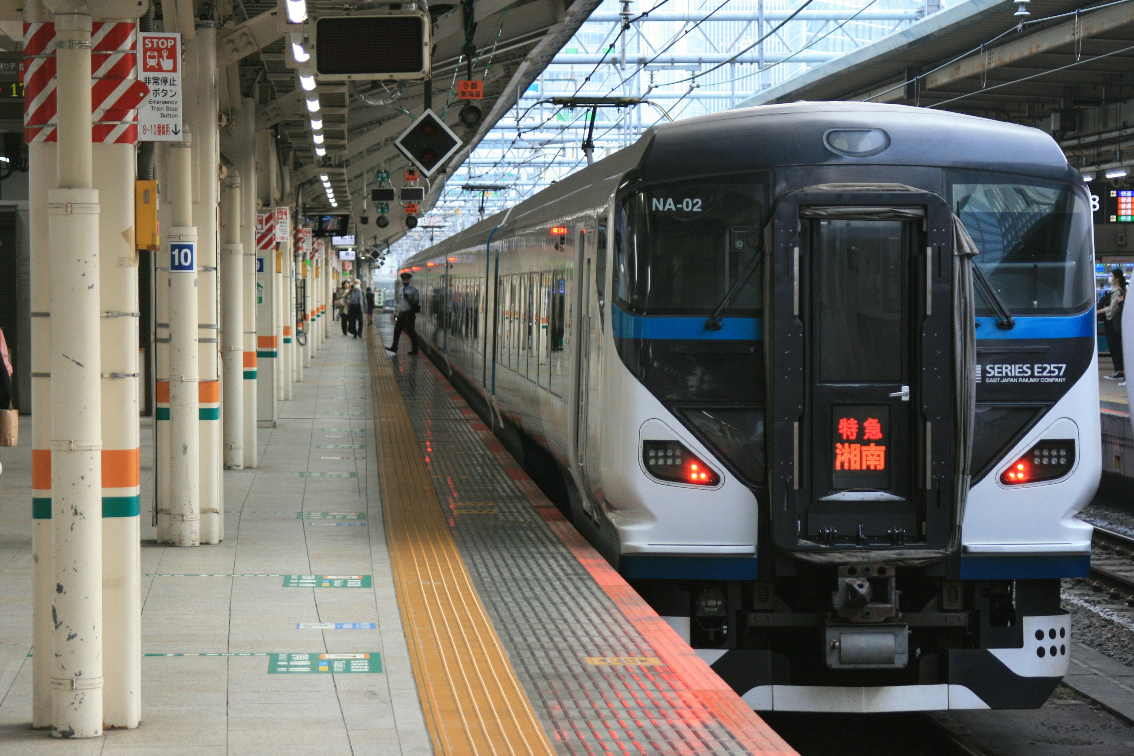 Sebuah kereta hitam dan putih berhenti di peron stasiun