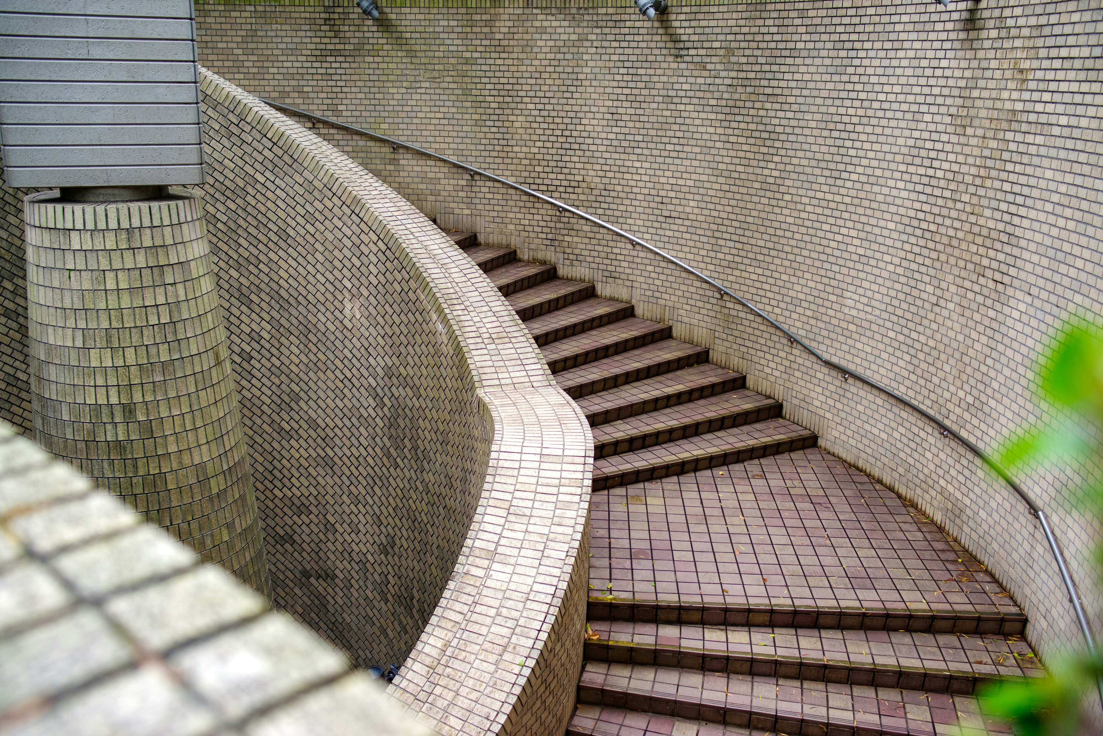 Modern architectural design featuring a curved staircase and tiled walls