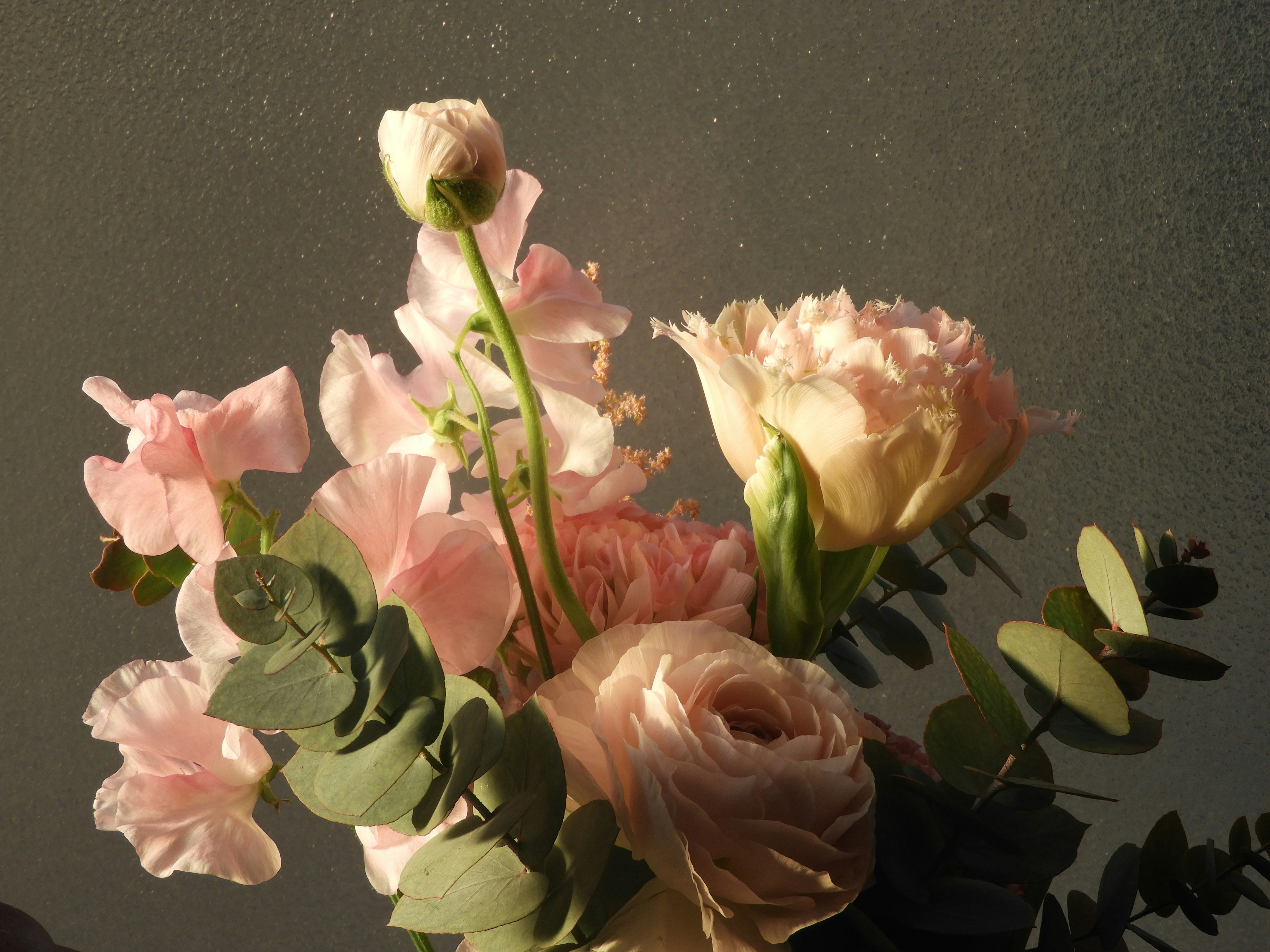 A bouquet of soft pink flowers and green leaves