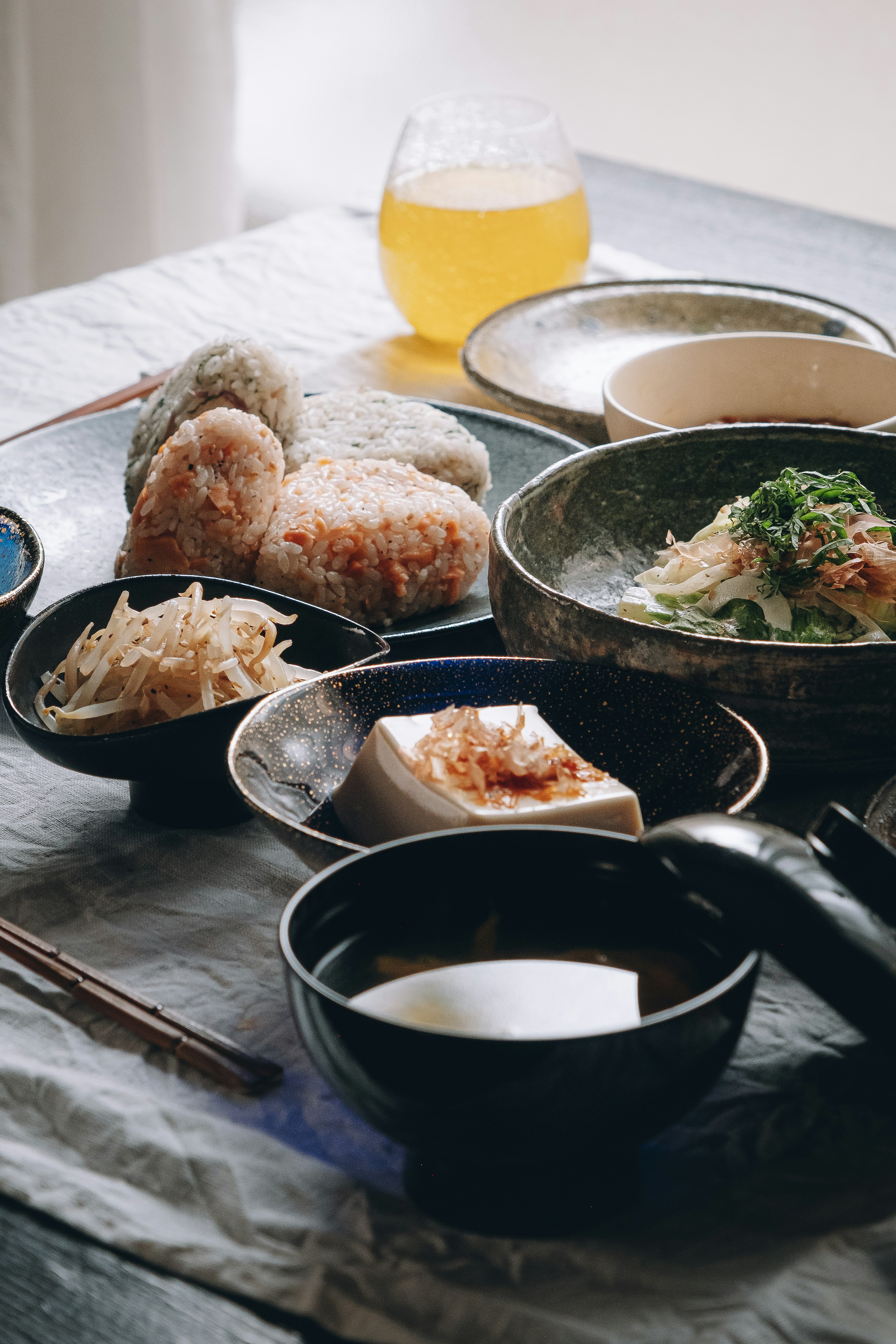 Une belle présentation de cuisine japonaise avec des onigiri, de la soupe miso et une salade de style japonais