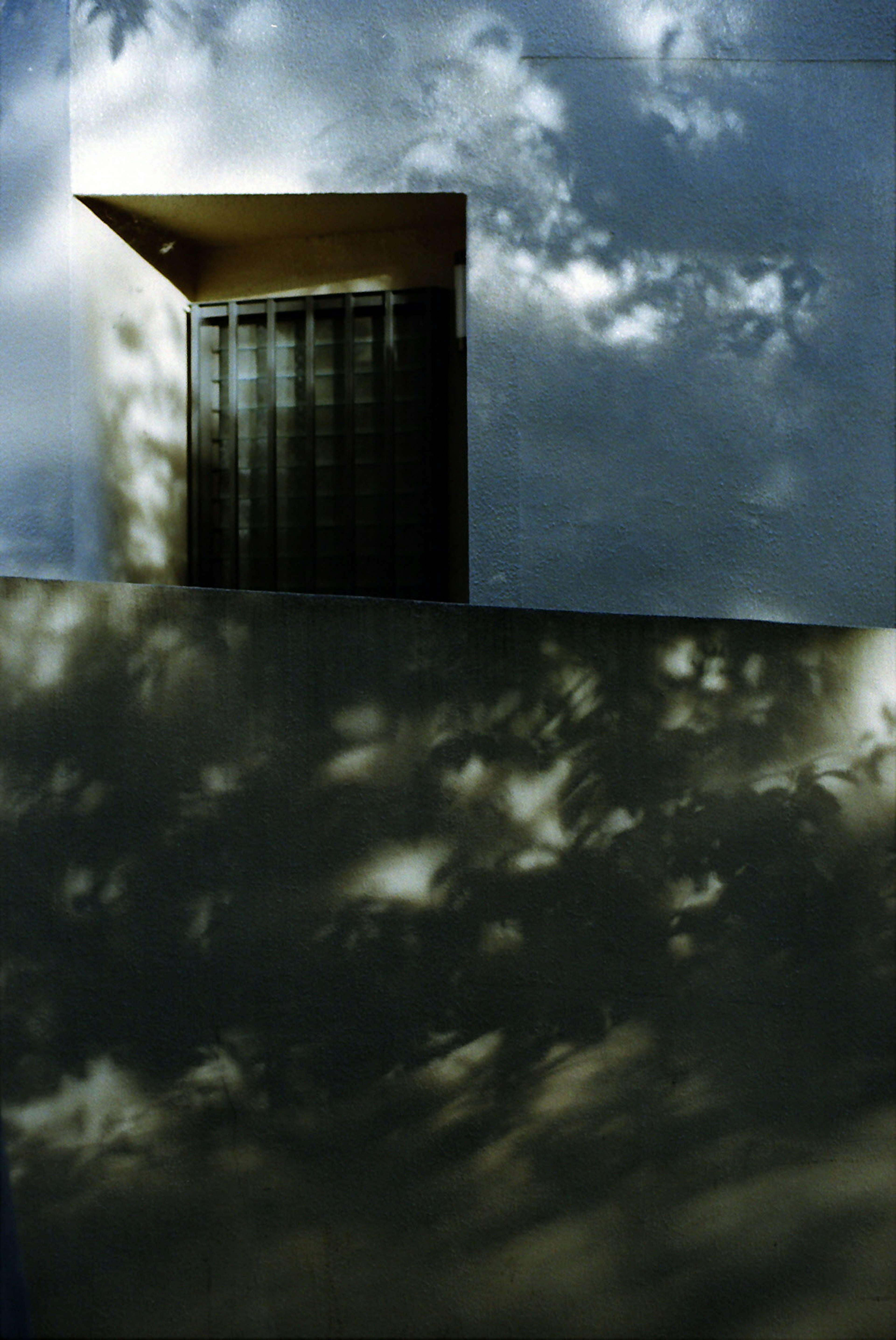 Ventana de un edificio moderno con sombras en la pared