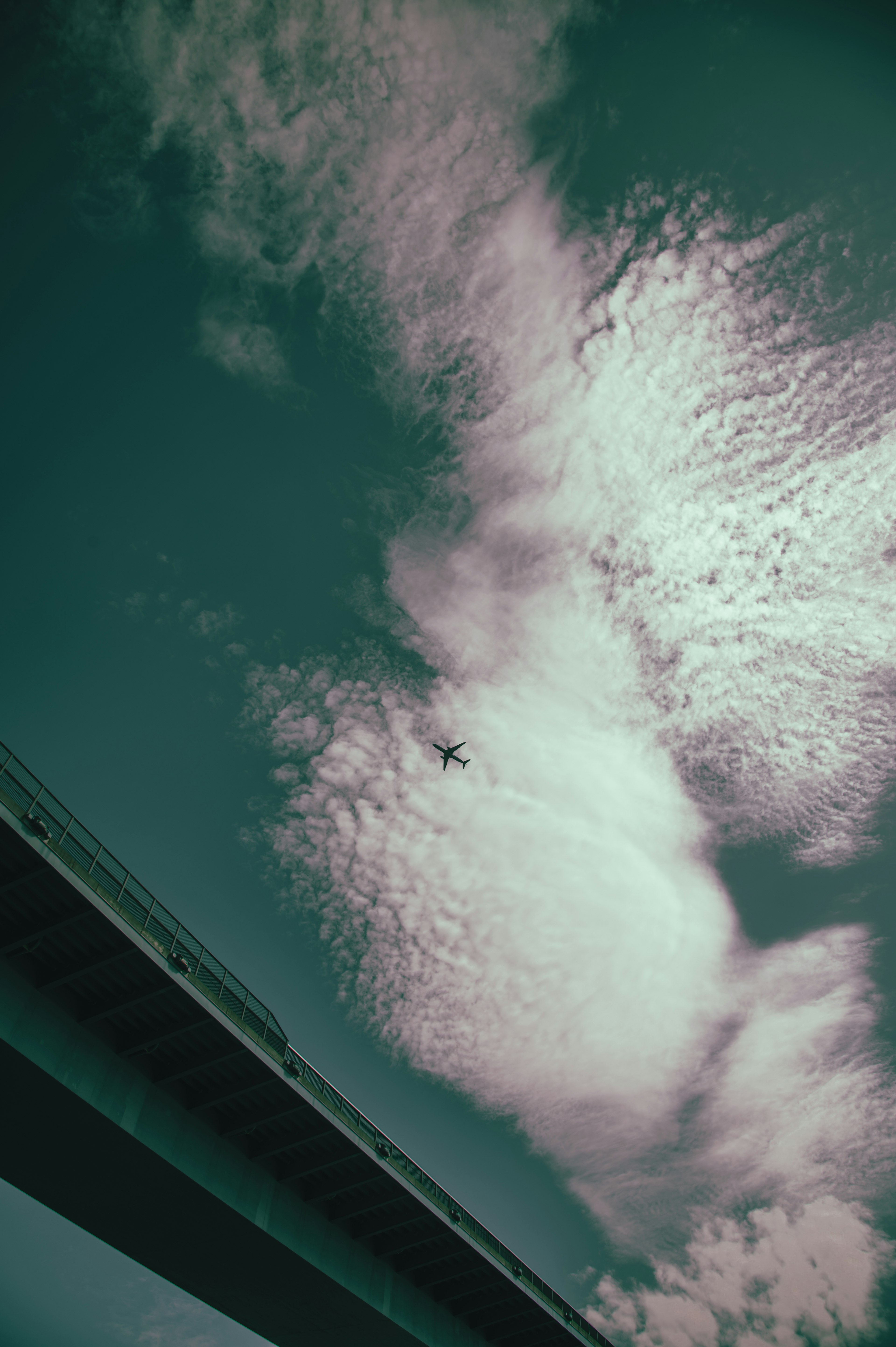 Una vista de nubes blancas contra un cielo azul con un puente abajo