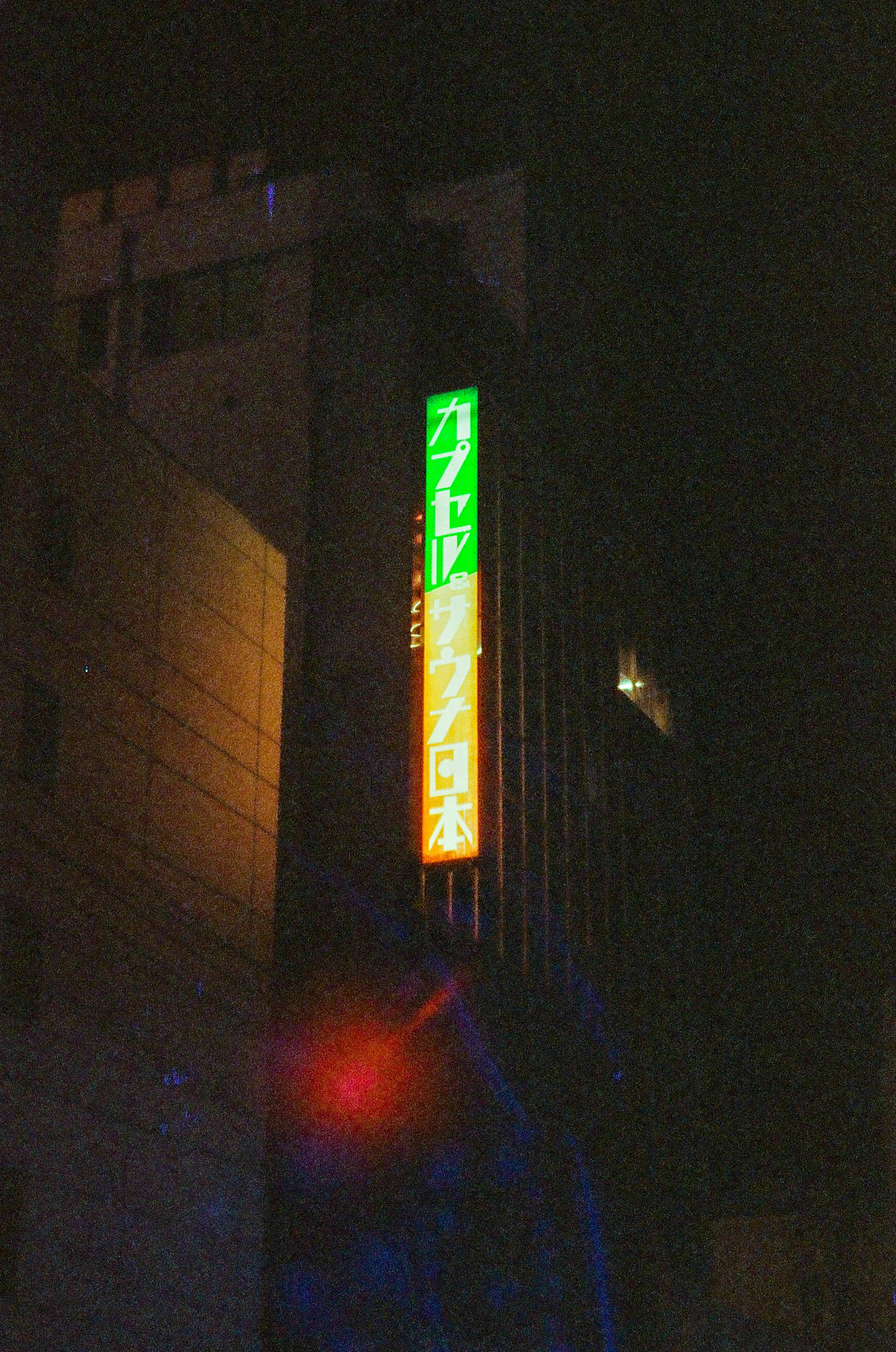 Cartel iluminado de un edificio en la ciudad de noche neón verde y naranja