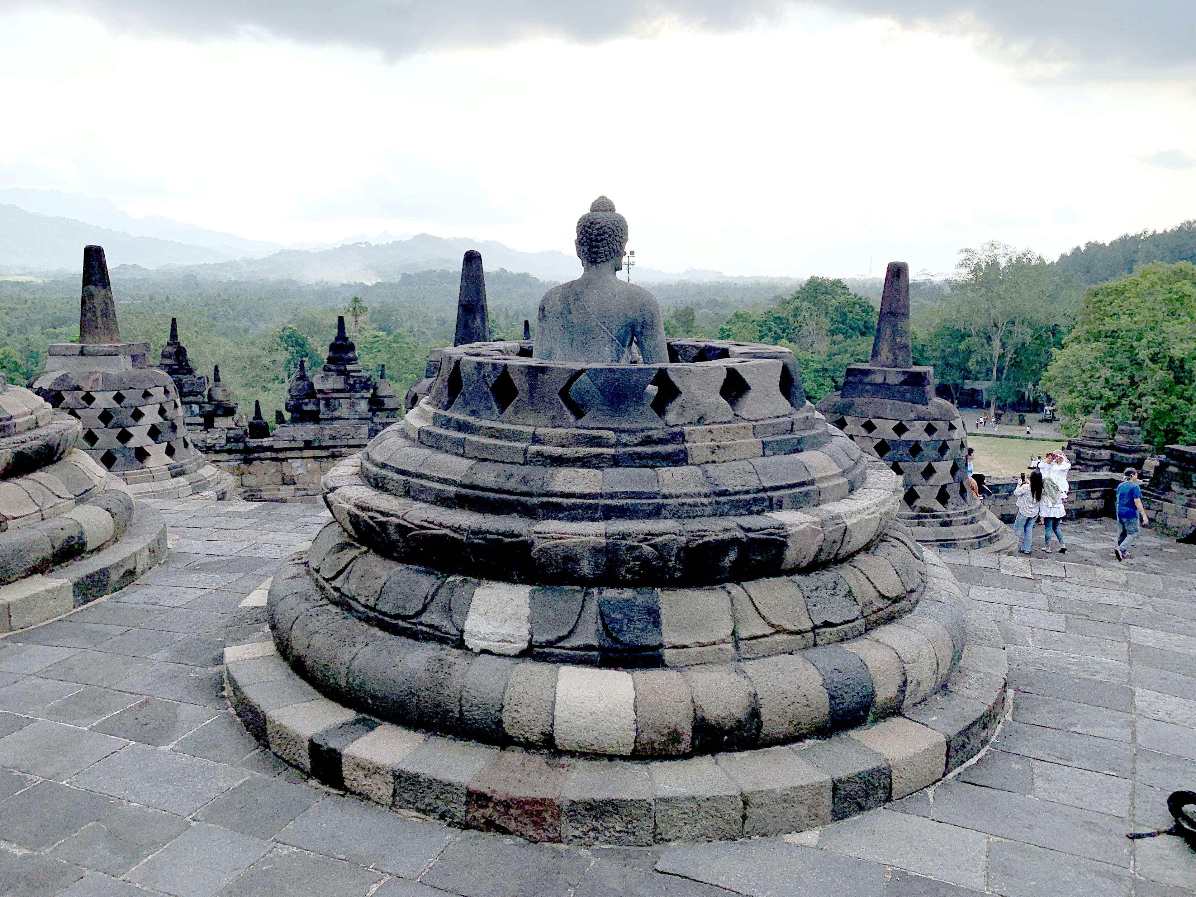 Cảnh quan của đền Borobudur với tượng Phật và tháp stupa