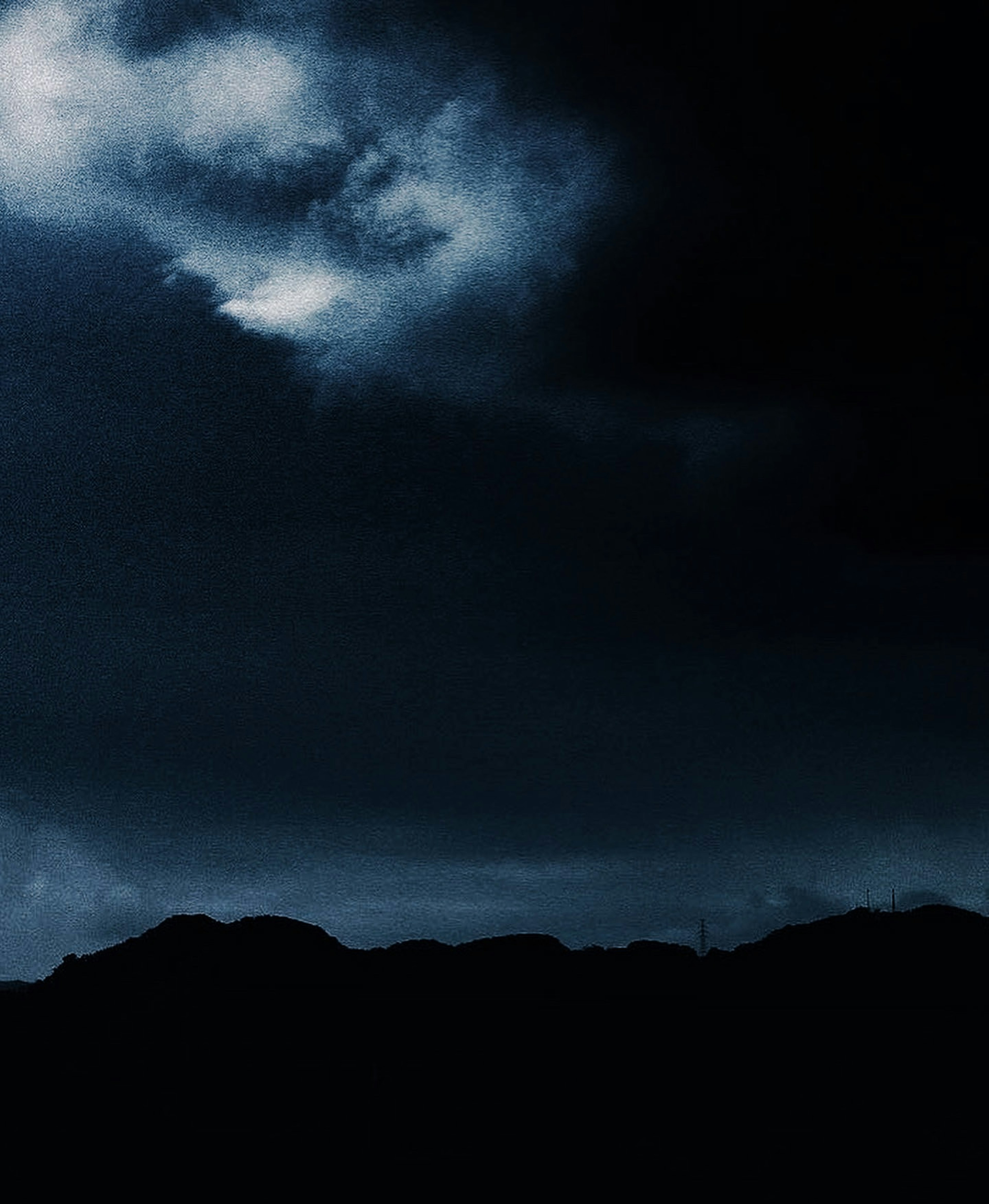 Silhouette of mountains under dark cloud cover