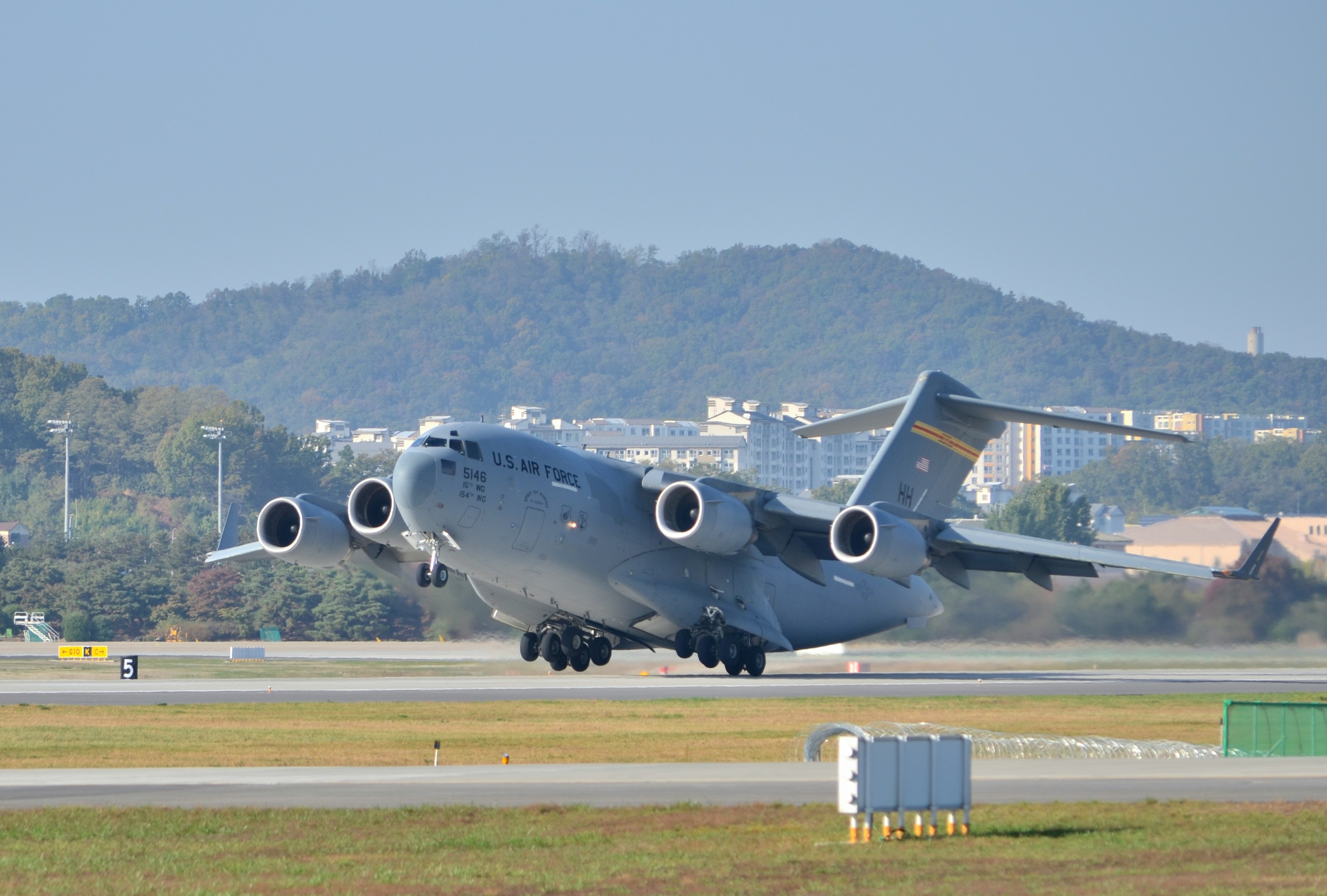 공항 활주로에서 이륙하는 대형 수송기의 이미지