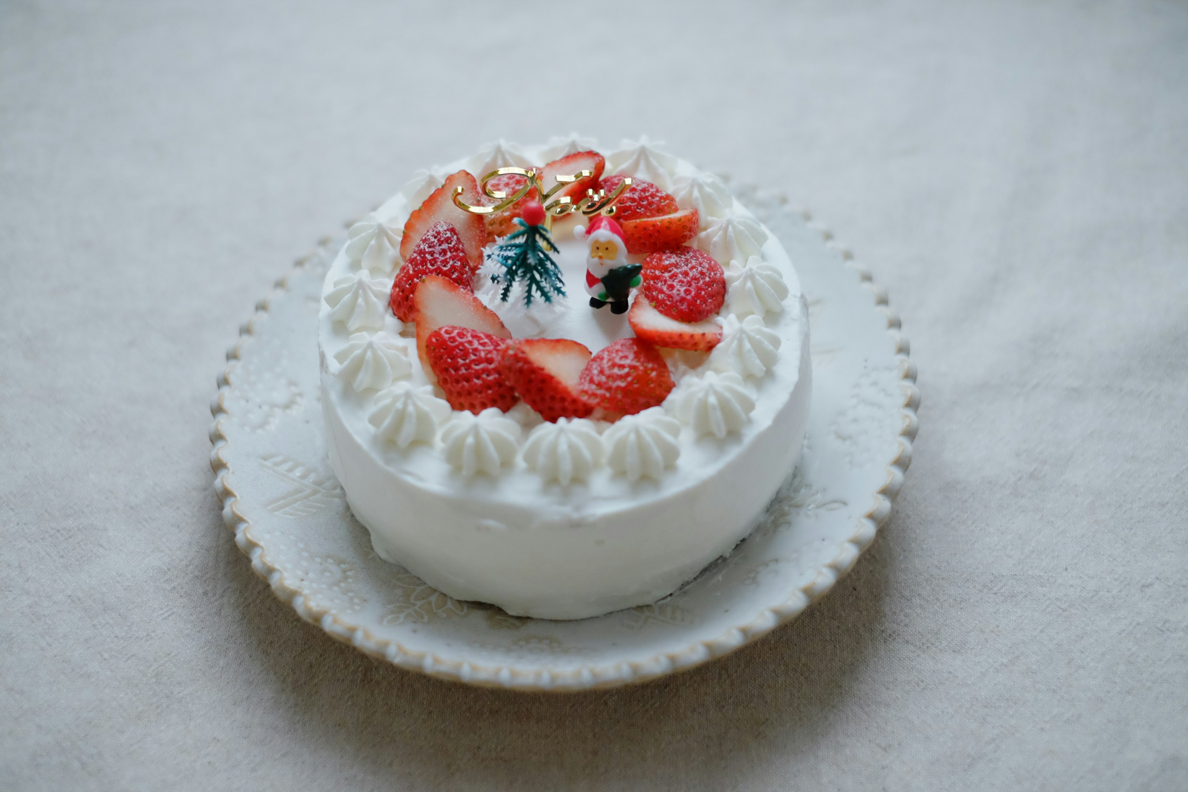 White cream cake topped with strawberries and decorative elements