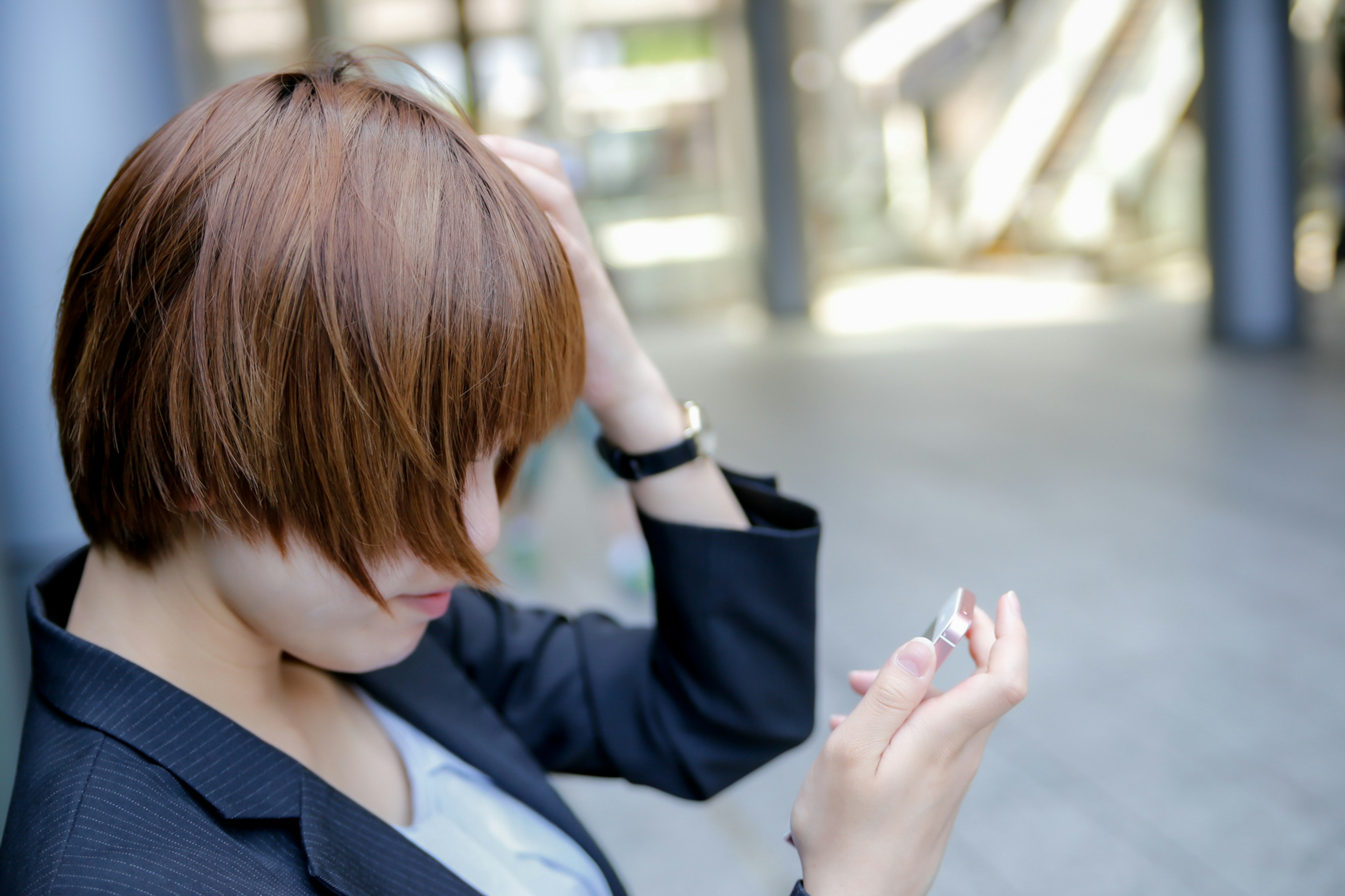 Mujer con cabello corto castaño mirando un teléfono inteligente