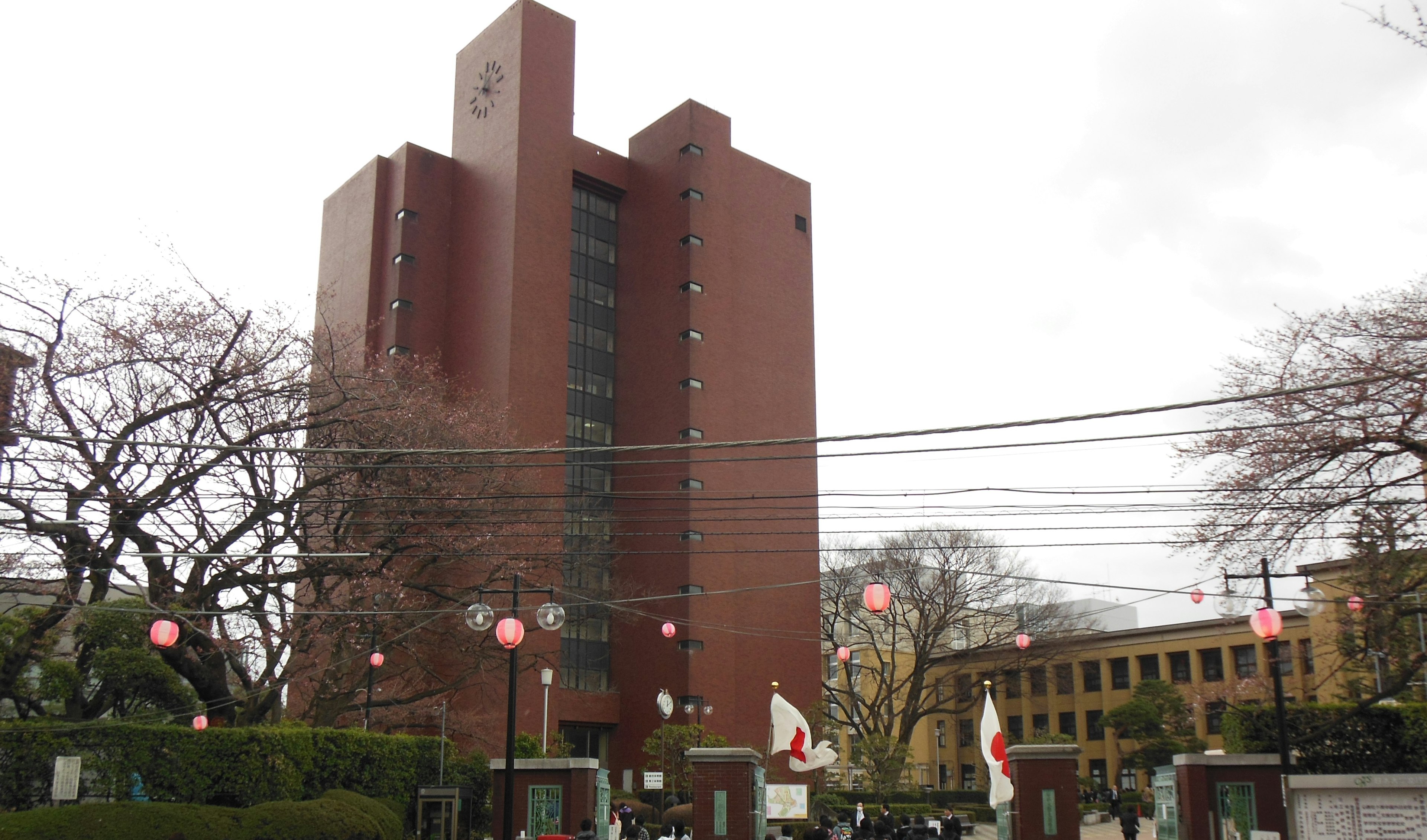 Red-brown building with cherry blossom trees