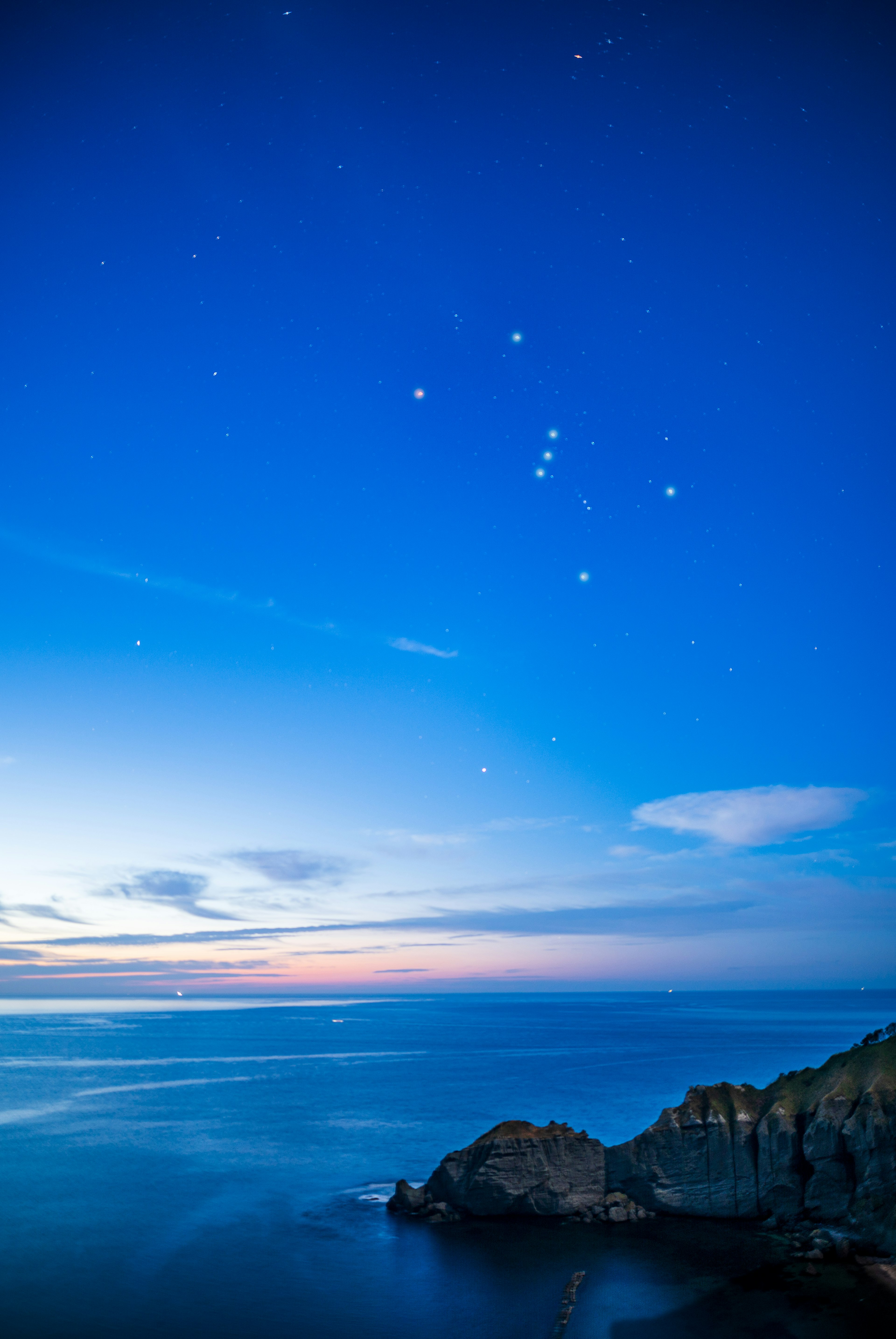 Paesaggio costiero al crepuscolo con cielo blu e stelle