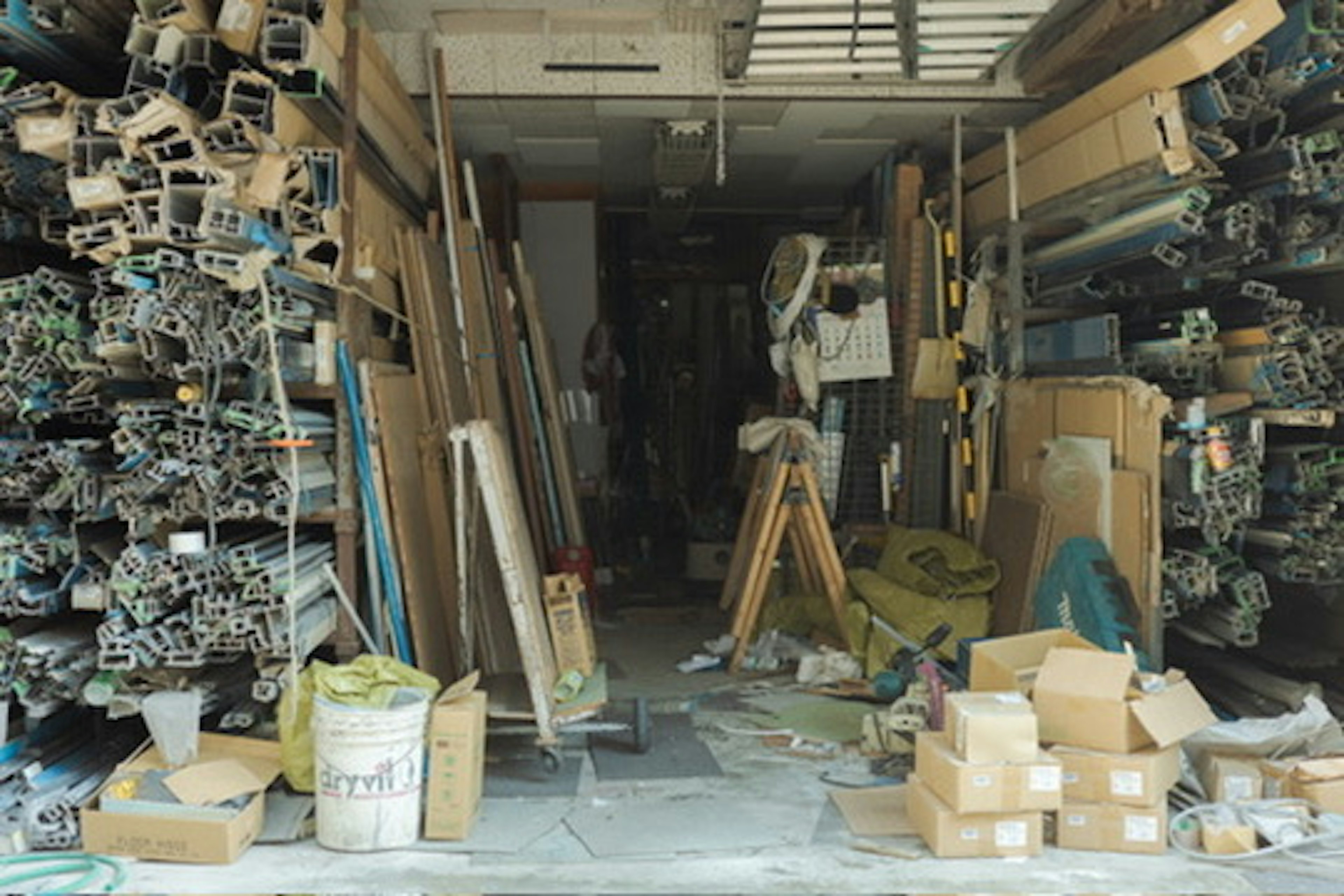 Interno di un laboratorio con materiali edili impilati e un lavoratore presente