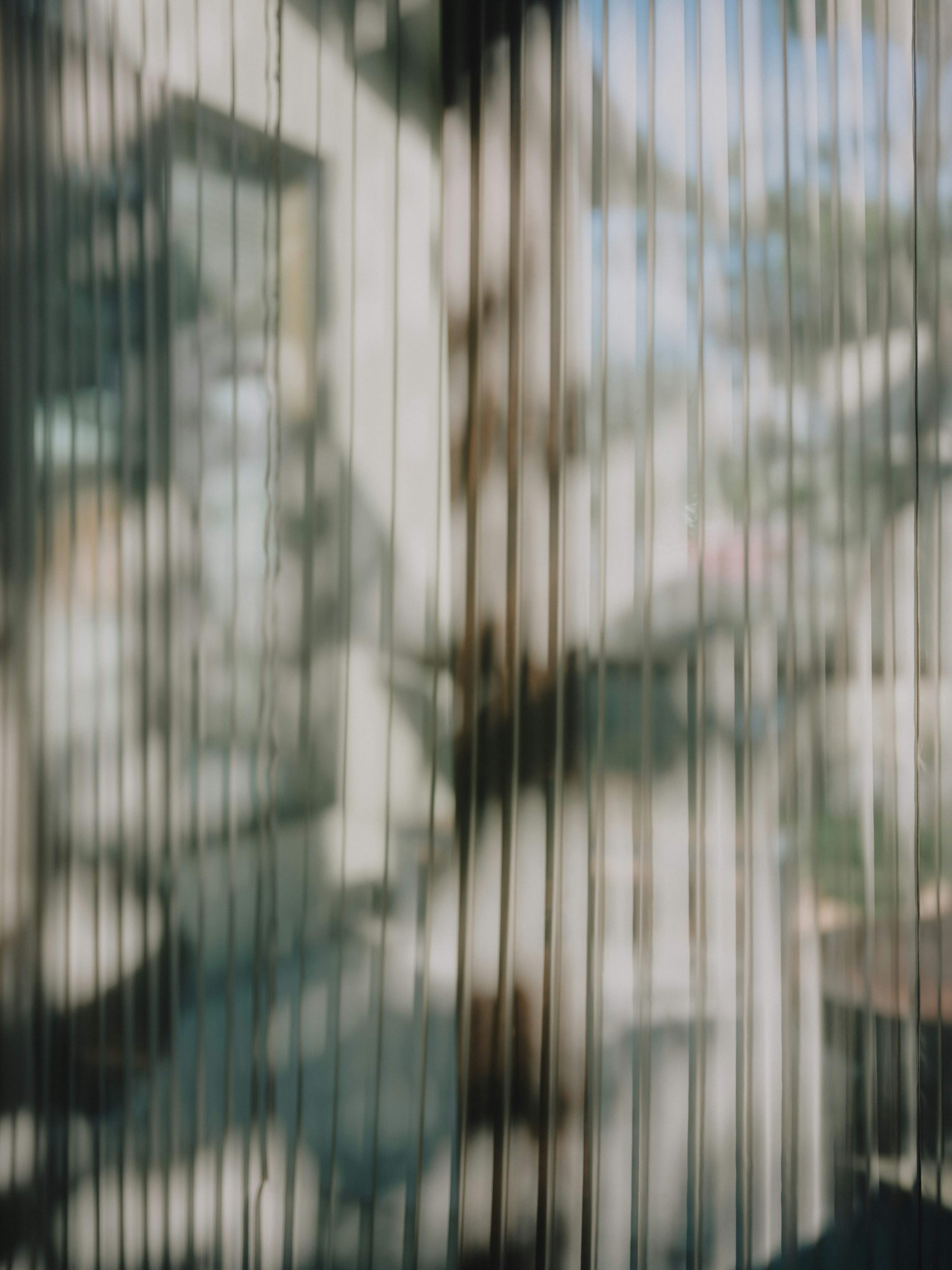 Blurry view through striped curtains with light filtering and shadows