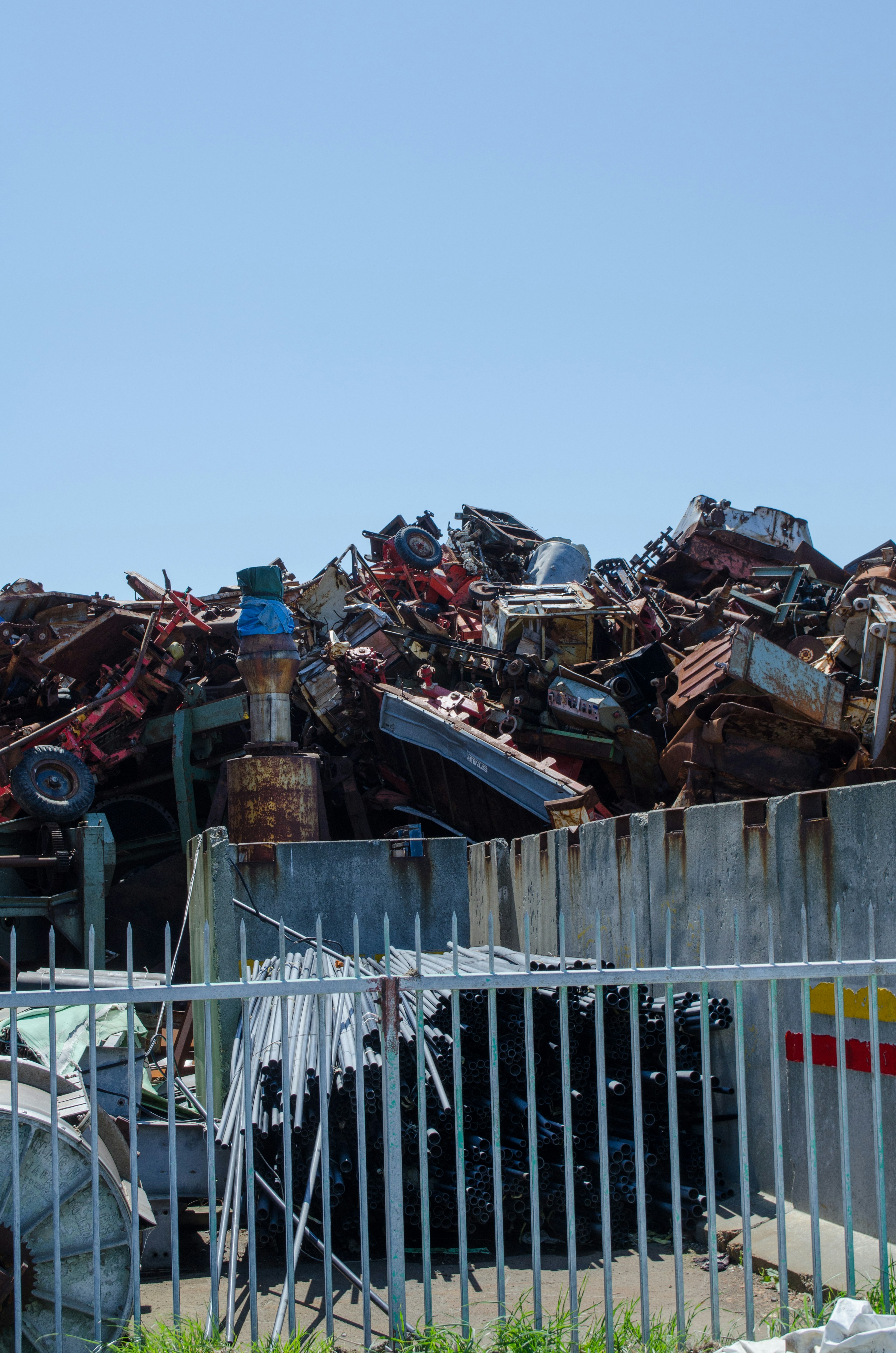 A heap of junk cars and metal scrap piled up at a junkyard