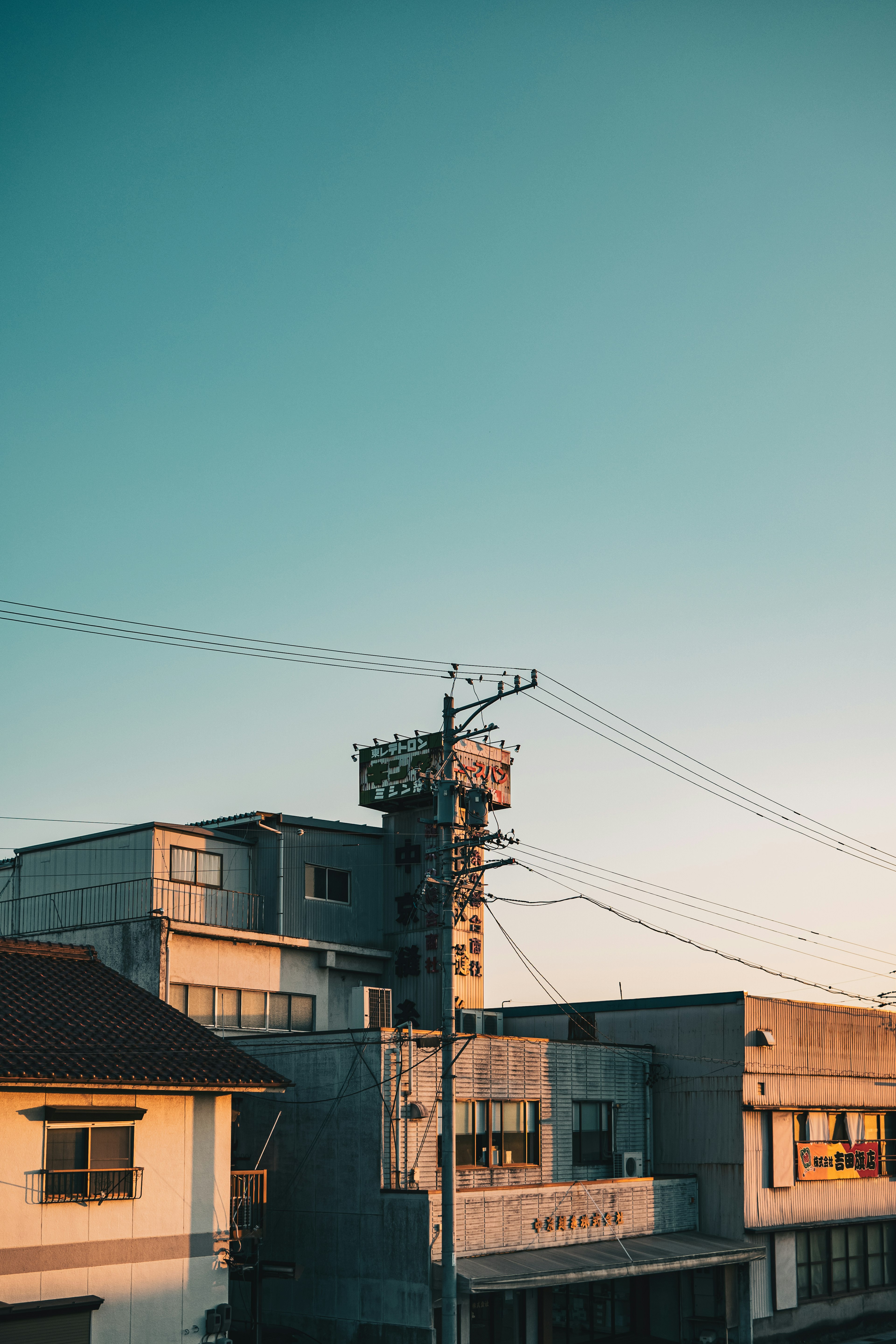 Urban landscape featuring buildings and a power pole under a clear sky