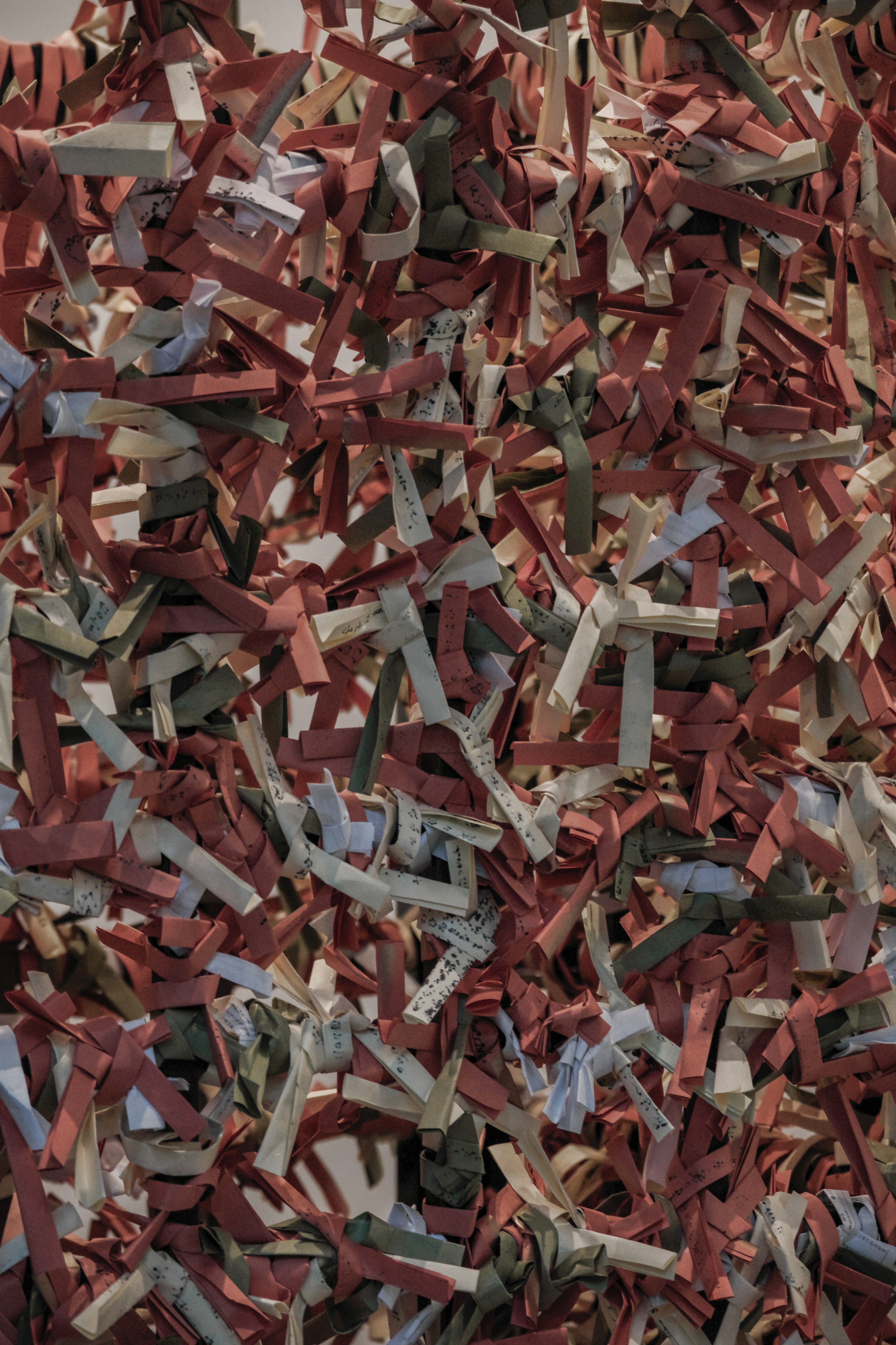 Textured surface of mixed shredded paper in red and green hues