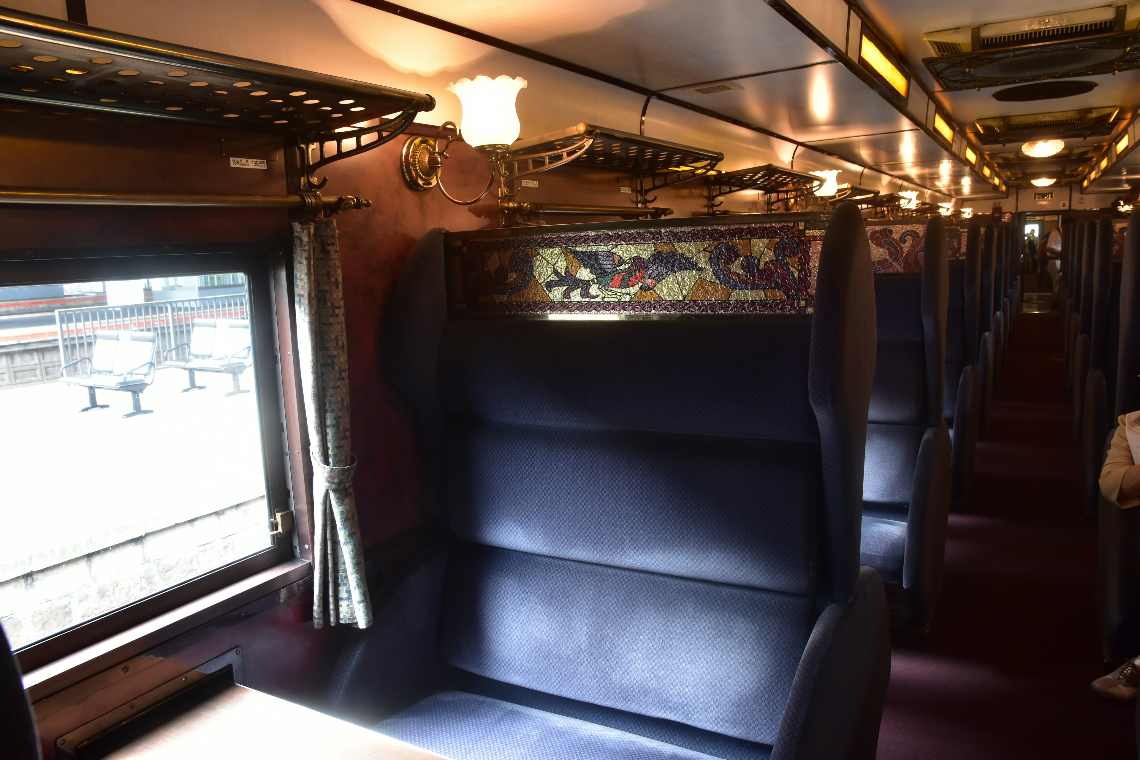 Interior view of a train with plush seating and decorative window design