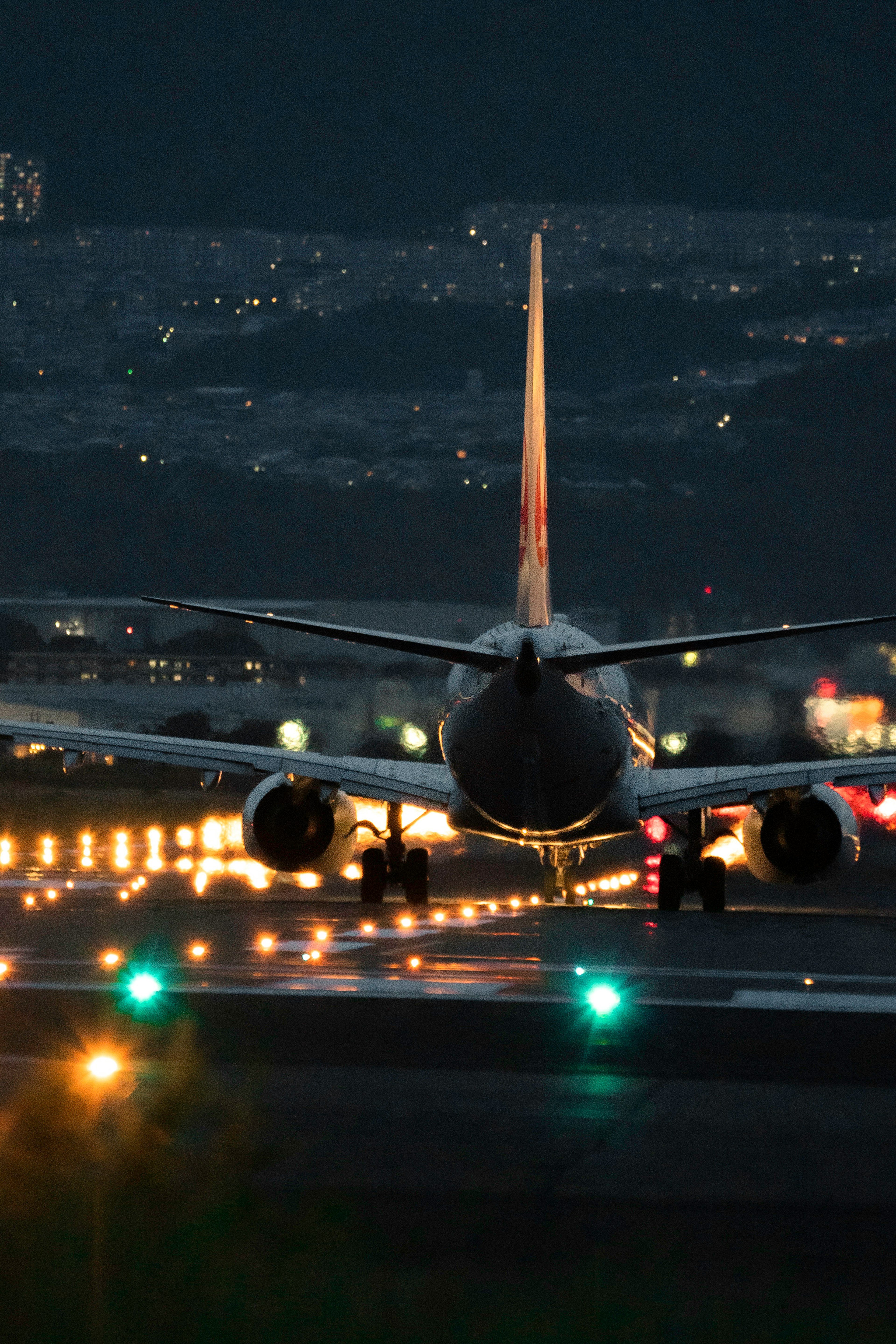 Immagine di un aereo sulla pista di notte che mostra la vista posteriore