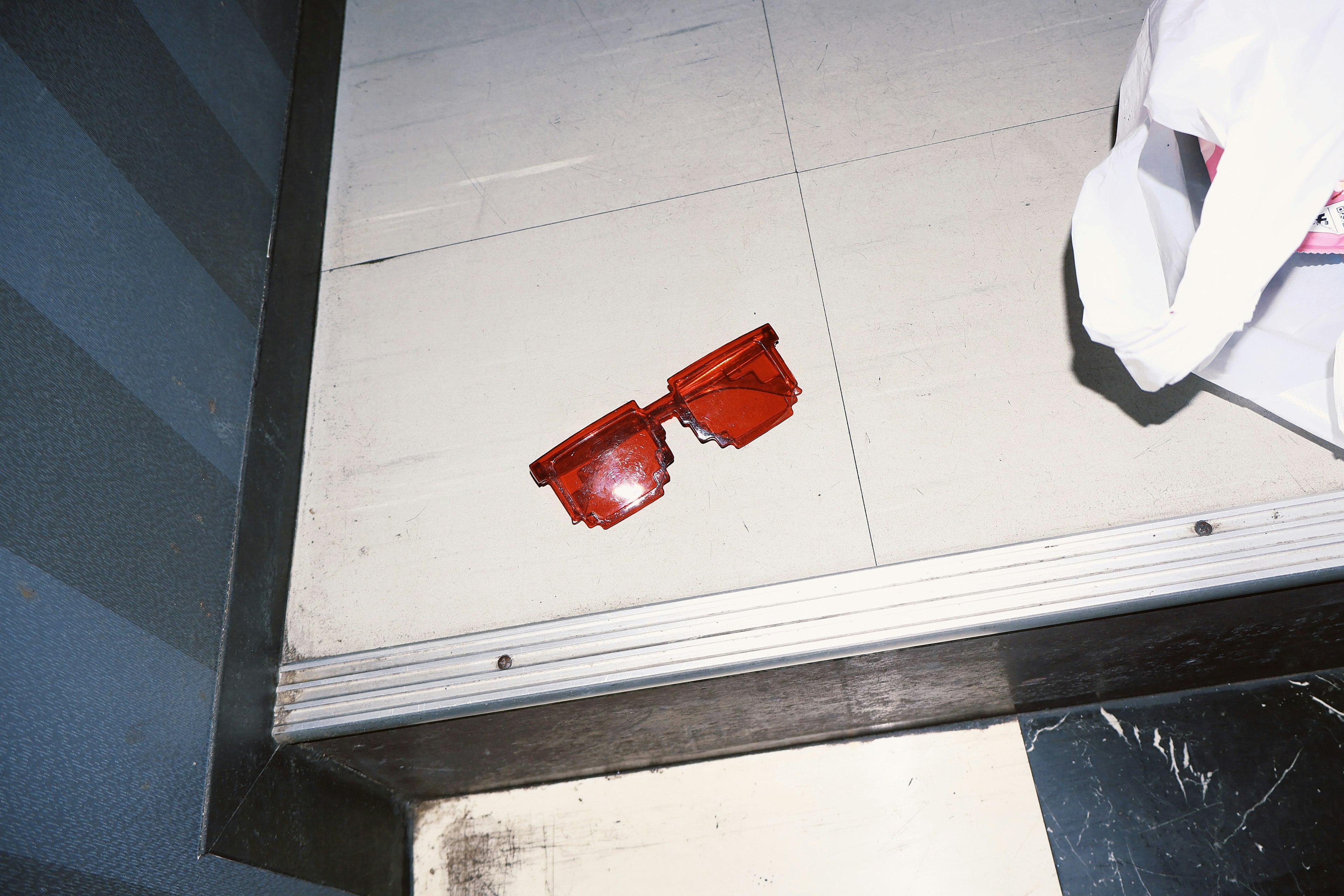 Red sunglasses lying on the floor