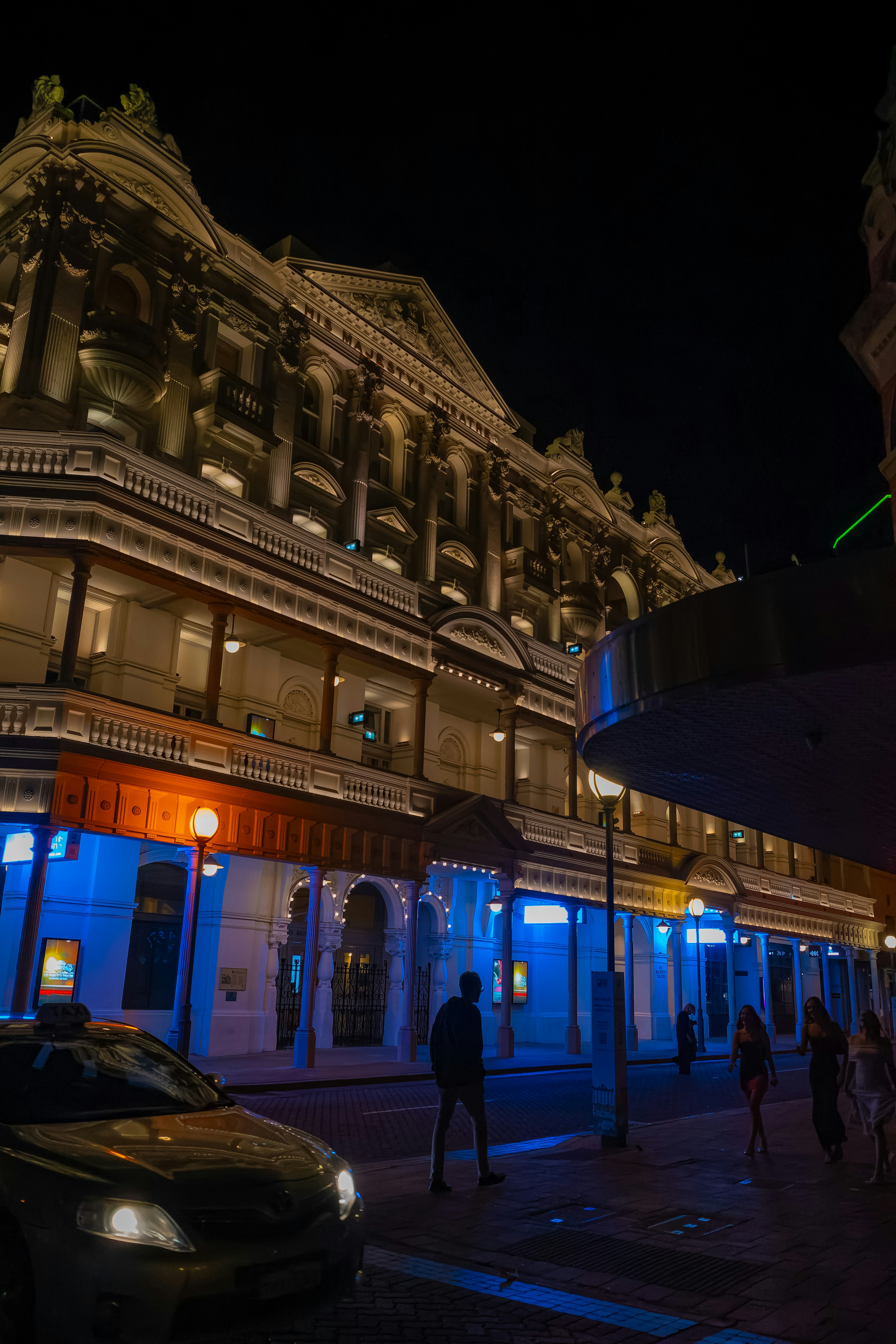 Historisches Gebäude, das nachts von blauen Lichtern beleuchtet wird