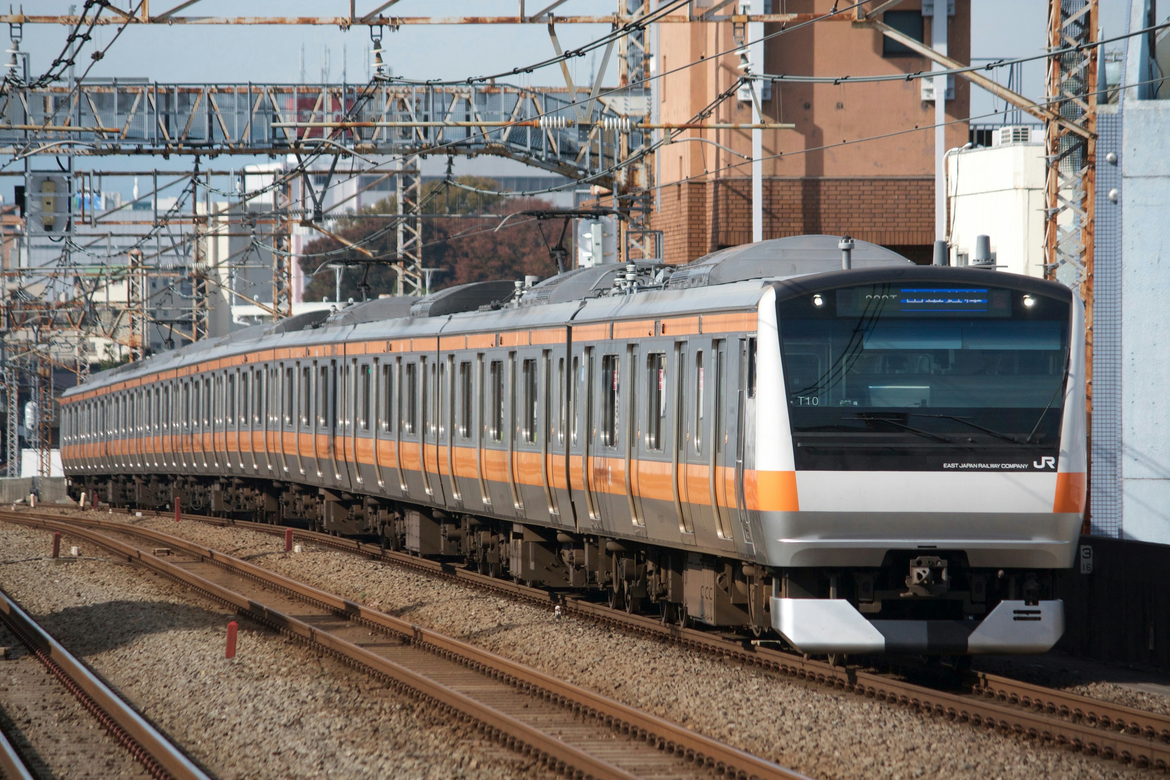 Treno arancione e argento che corre su binari