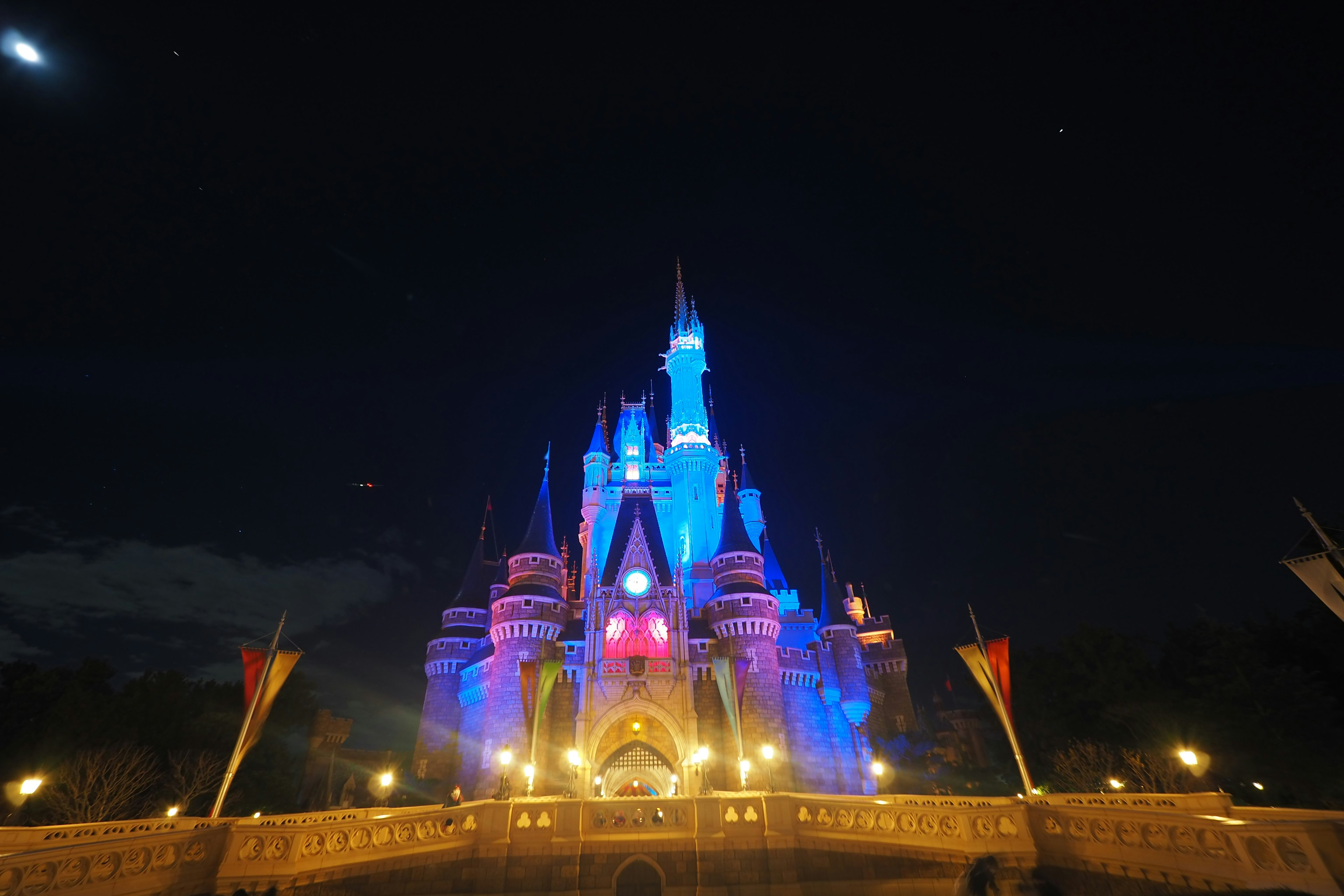 Cinderella Castle illuminated in blue and white lights at night