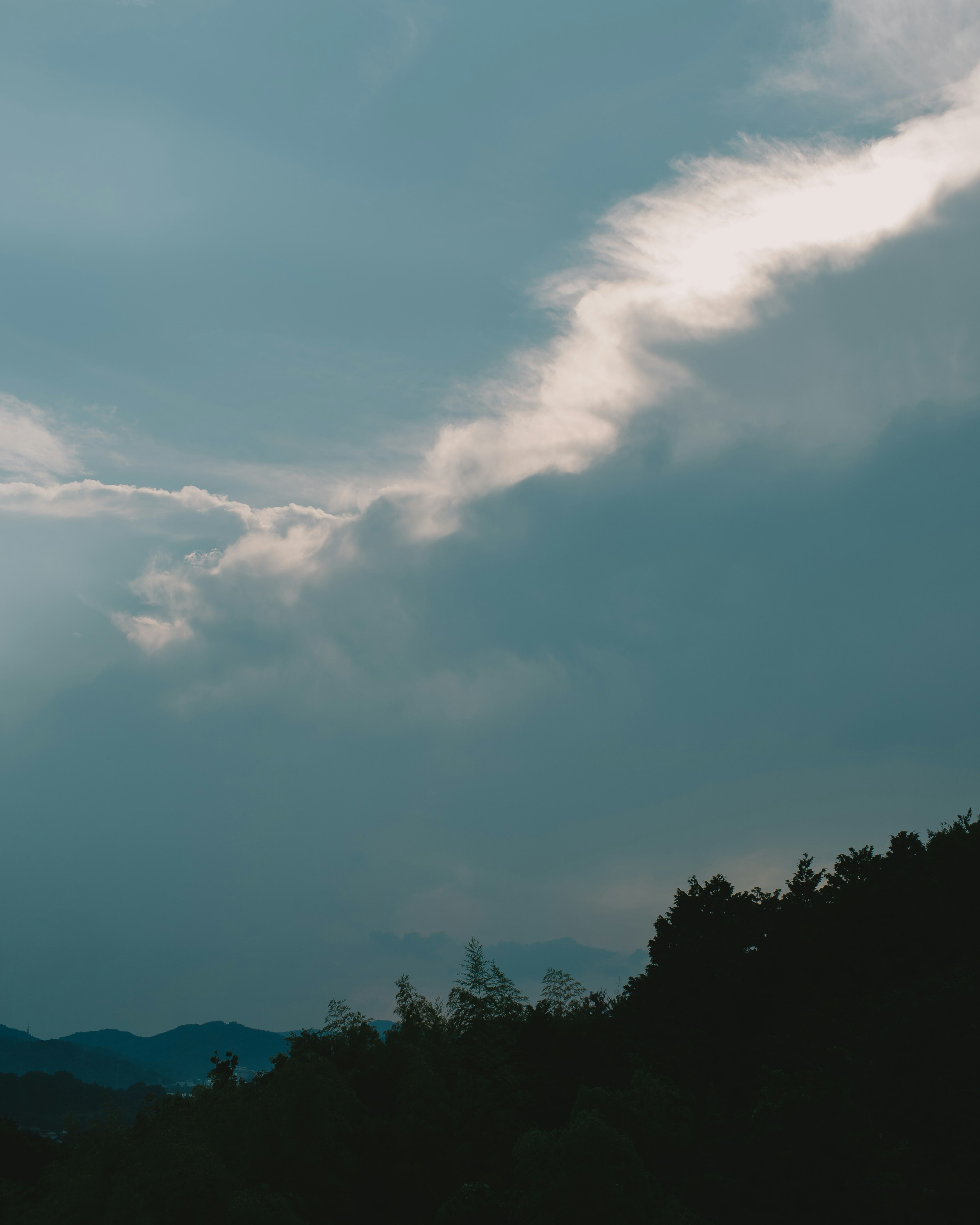 A view of cloudy sky with mountains in the background