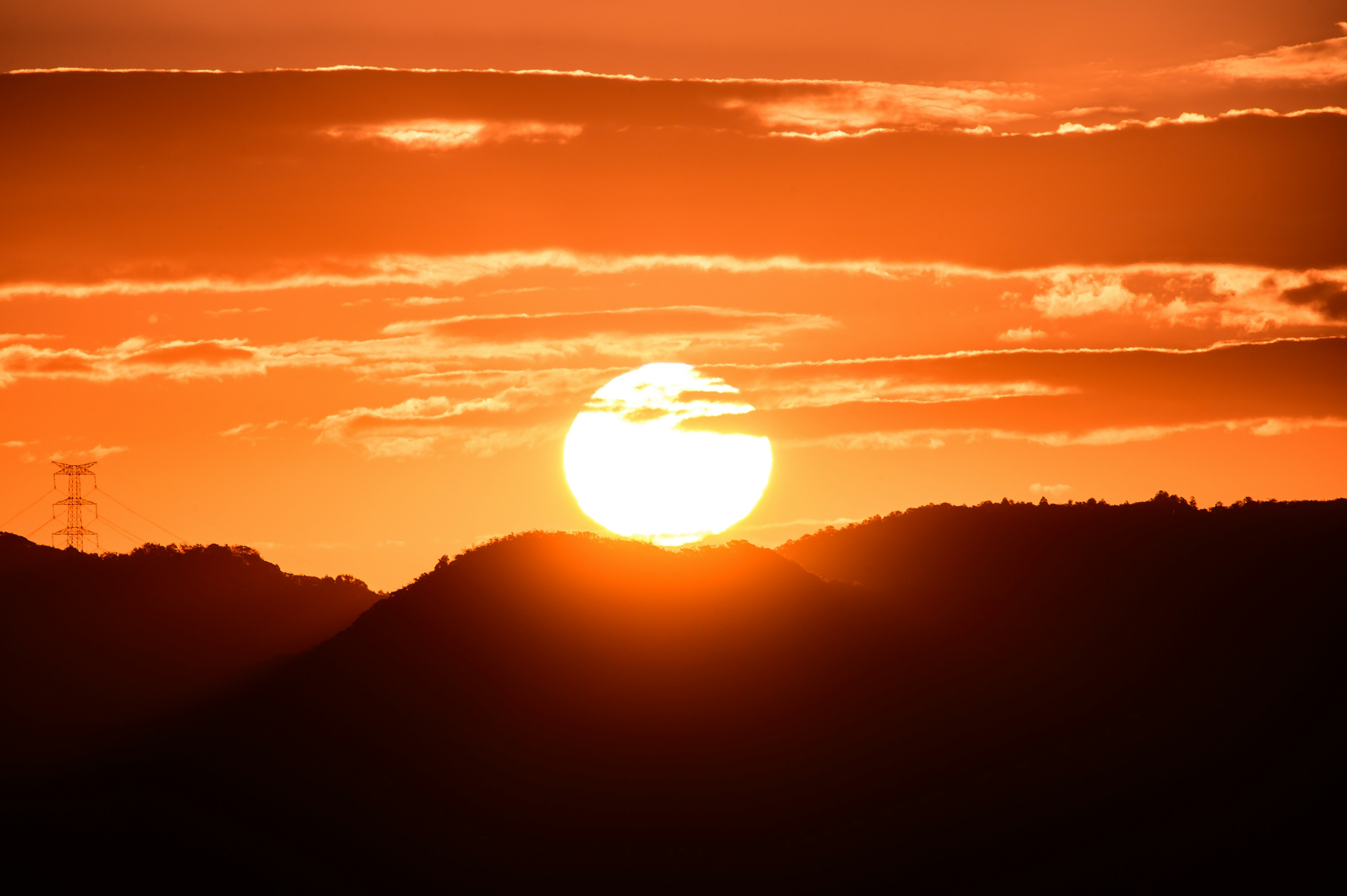 美しい夕日のシルエットが山々の上に広がるオレンジ色の空