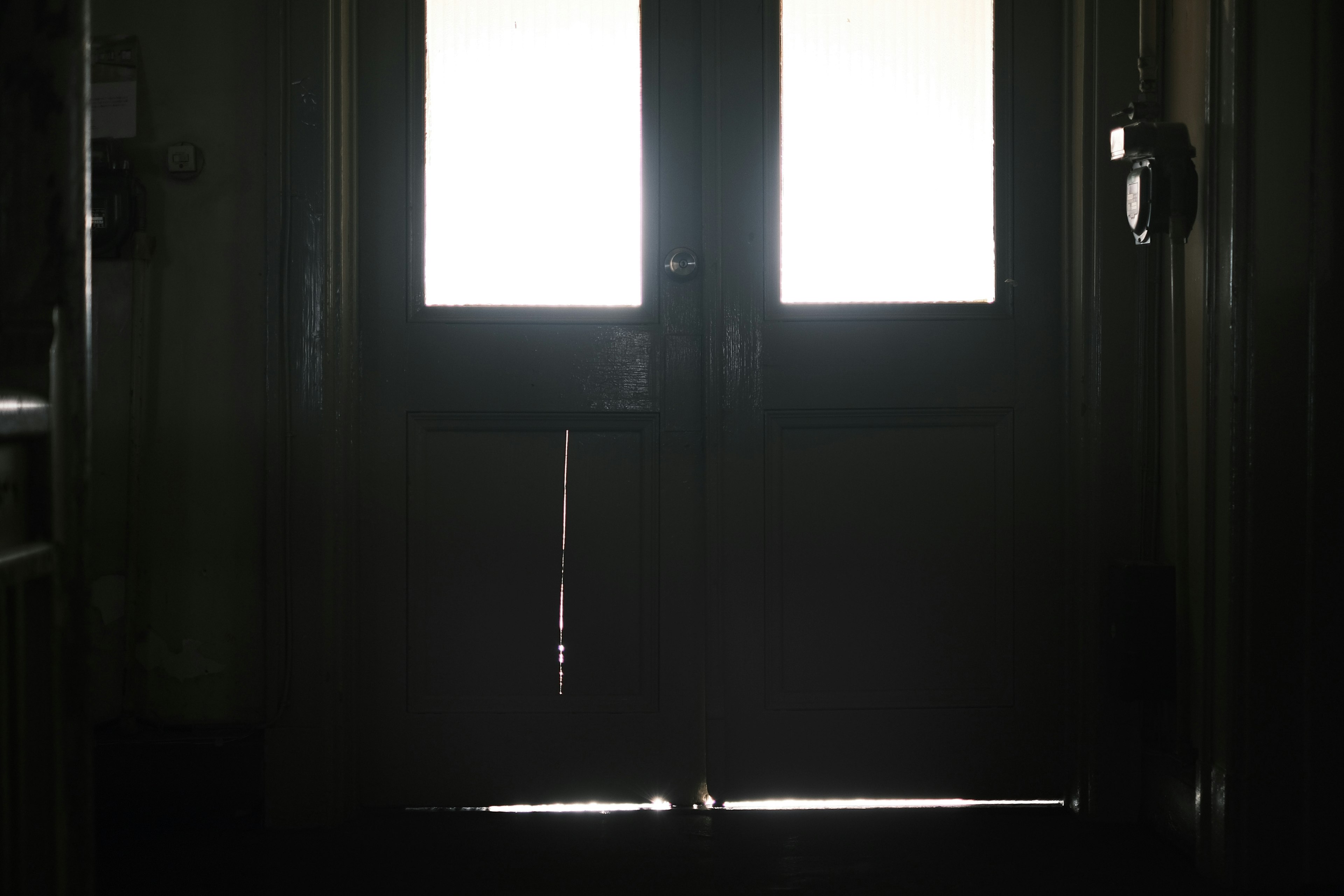 Two doors at the end of a dark hallway reflecting light